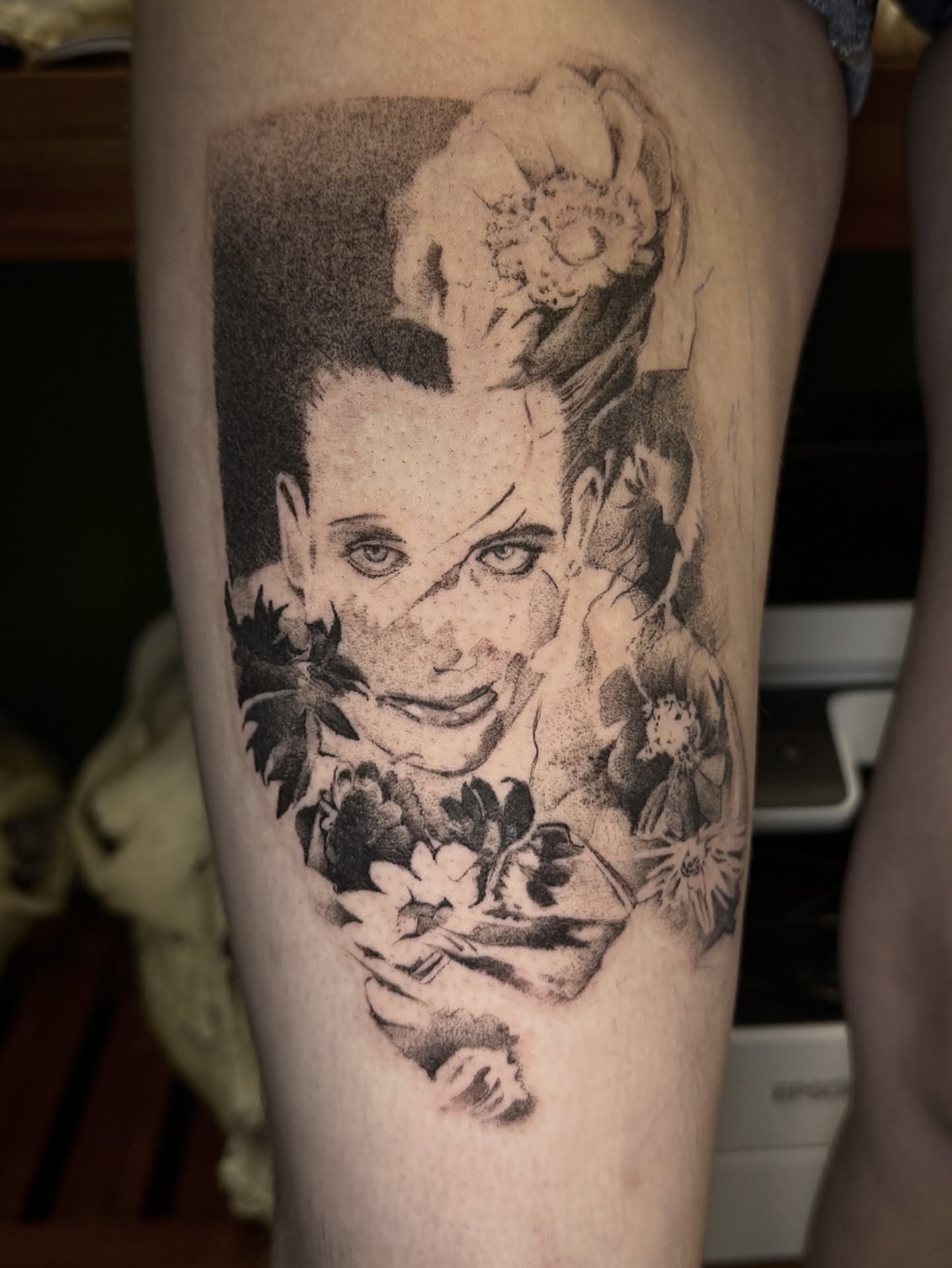 Portrait with floral elements dotwork tattoo on the thigh by Joe Hall