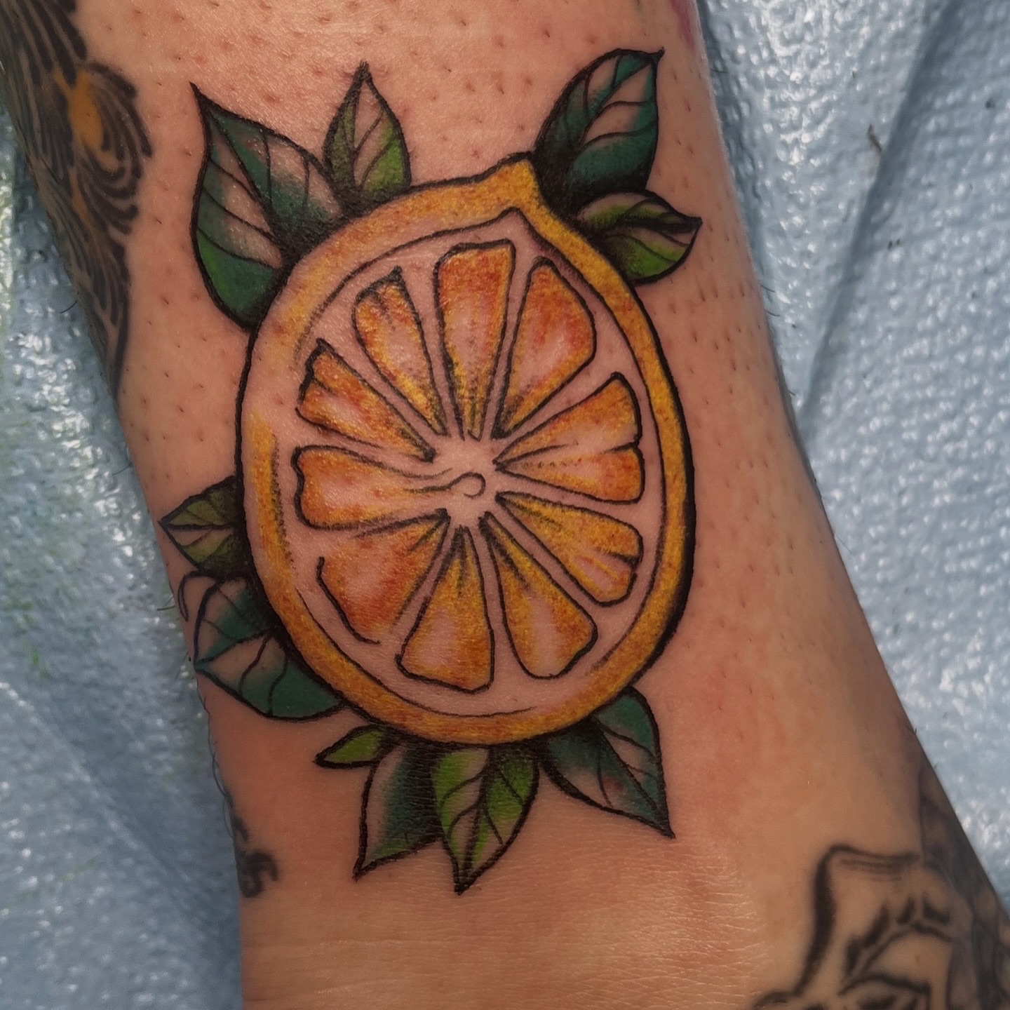 Orange slice American traditional tattoo on the forearm by ✨ Chris ✨