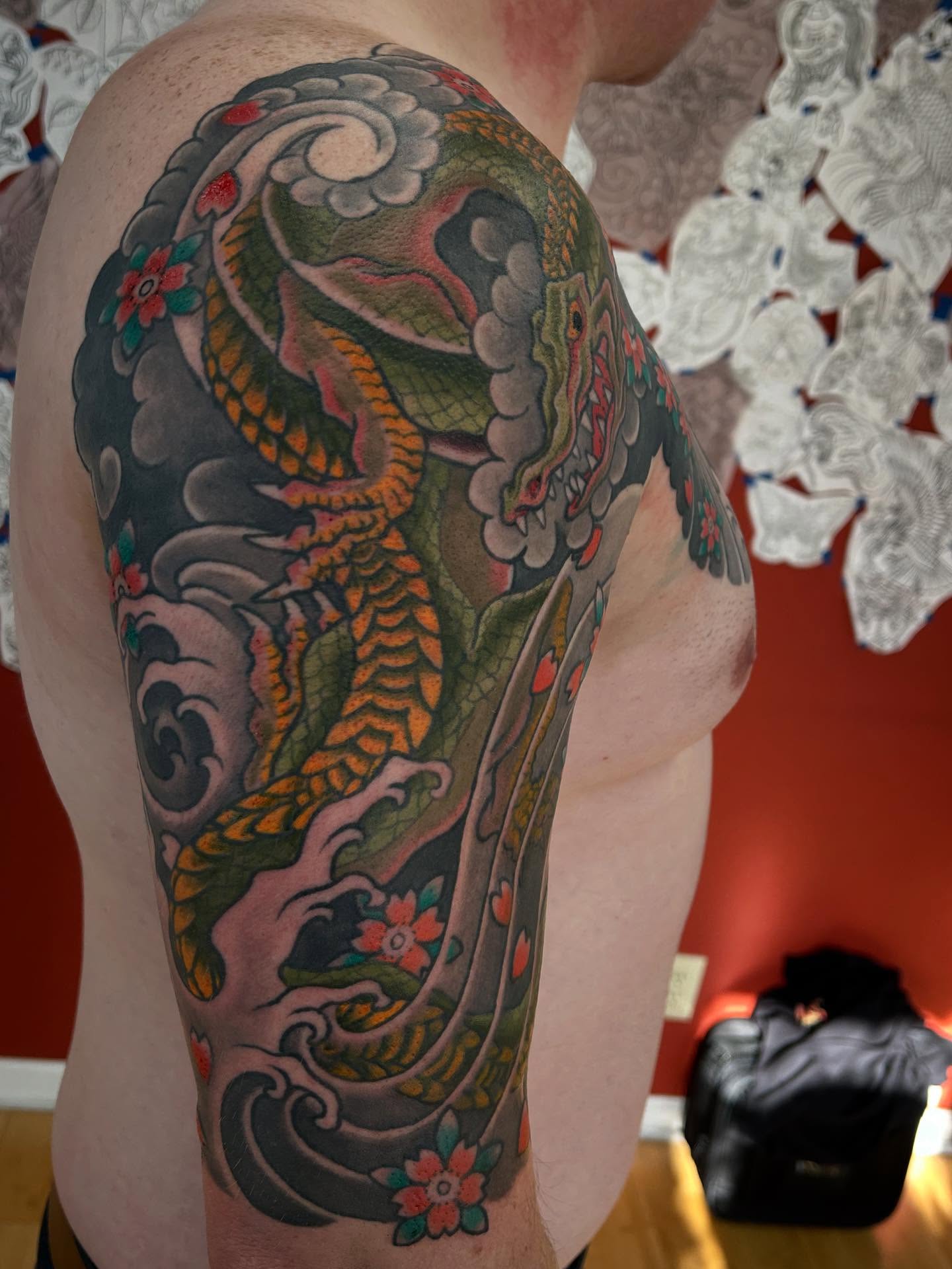 Dragon and waves japanese irezumi tattoo on the upper arm by Matthew Crimson