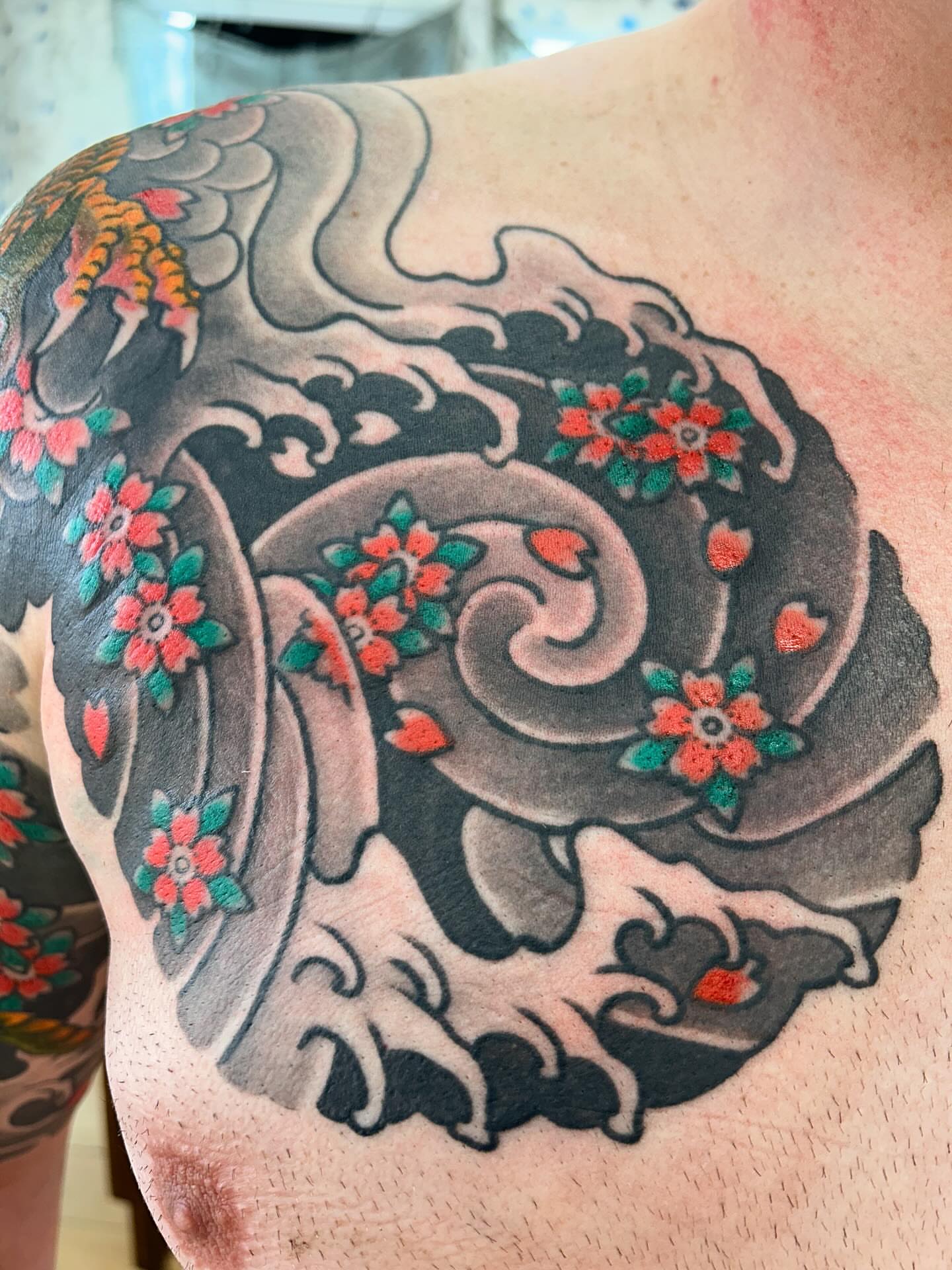 Wave and flowers japanese irezumi tattoo on the shoulder by Matthew Crimson