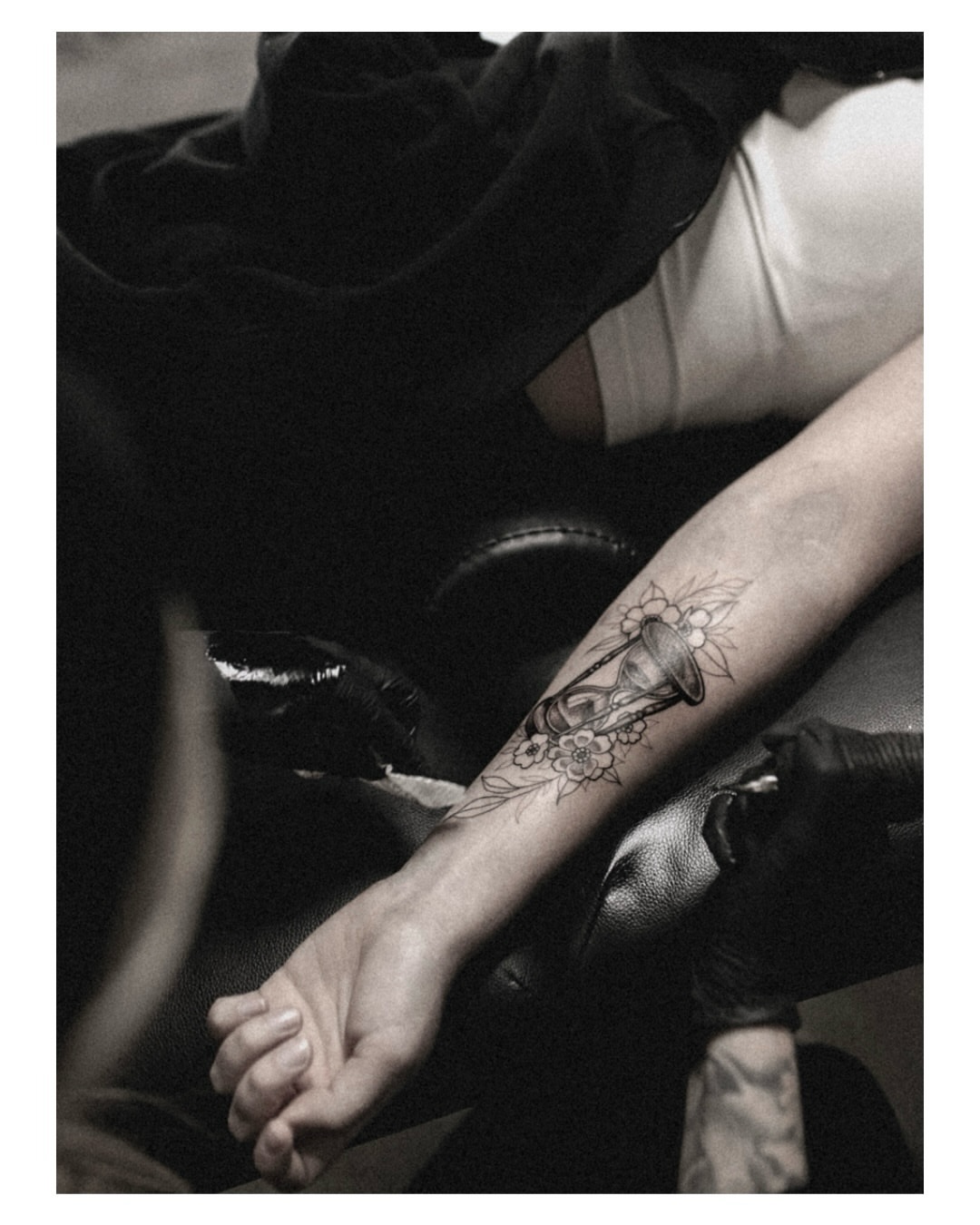Hourglass and flowers black and grey tattoo on the forearm by Jordyn Tinney