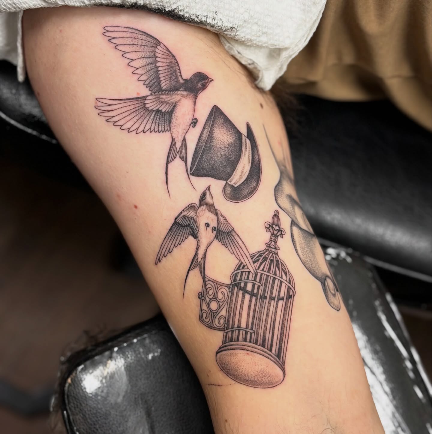 Birds and cage realism tattoo on the forearm by sydney honn