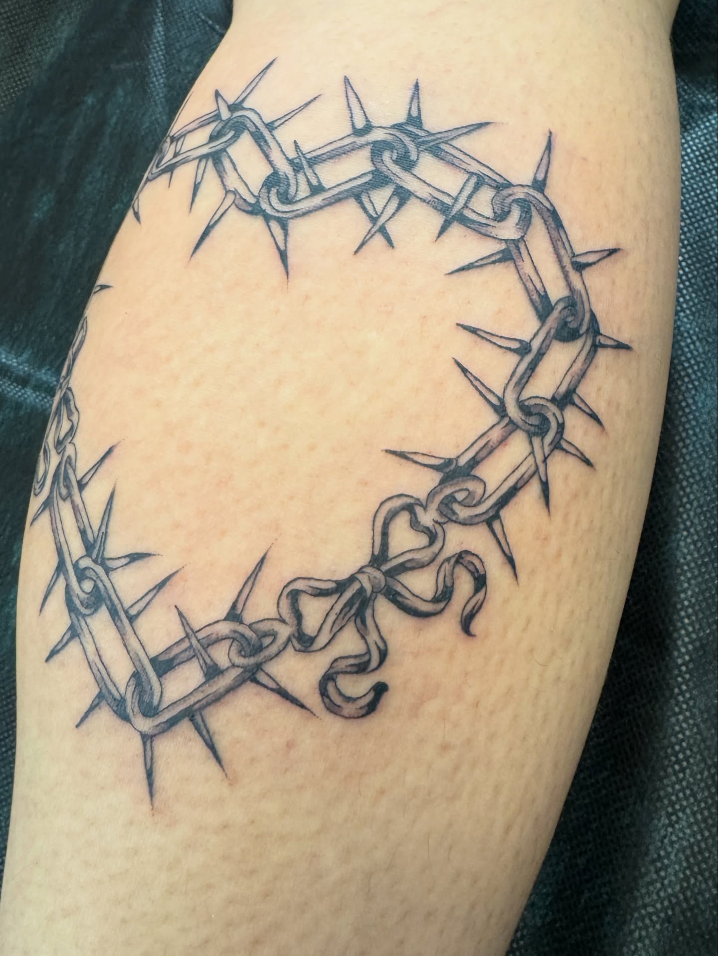 Crown of thorns black and grey tattoo on the forearm by Sarah Pham