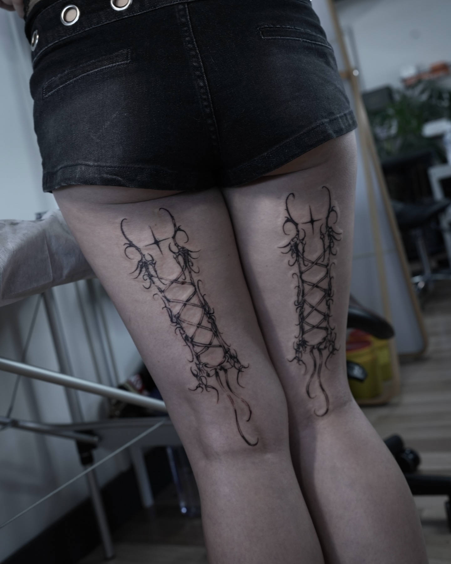 Corset black and grey tattoo on the thigh by Gun