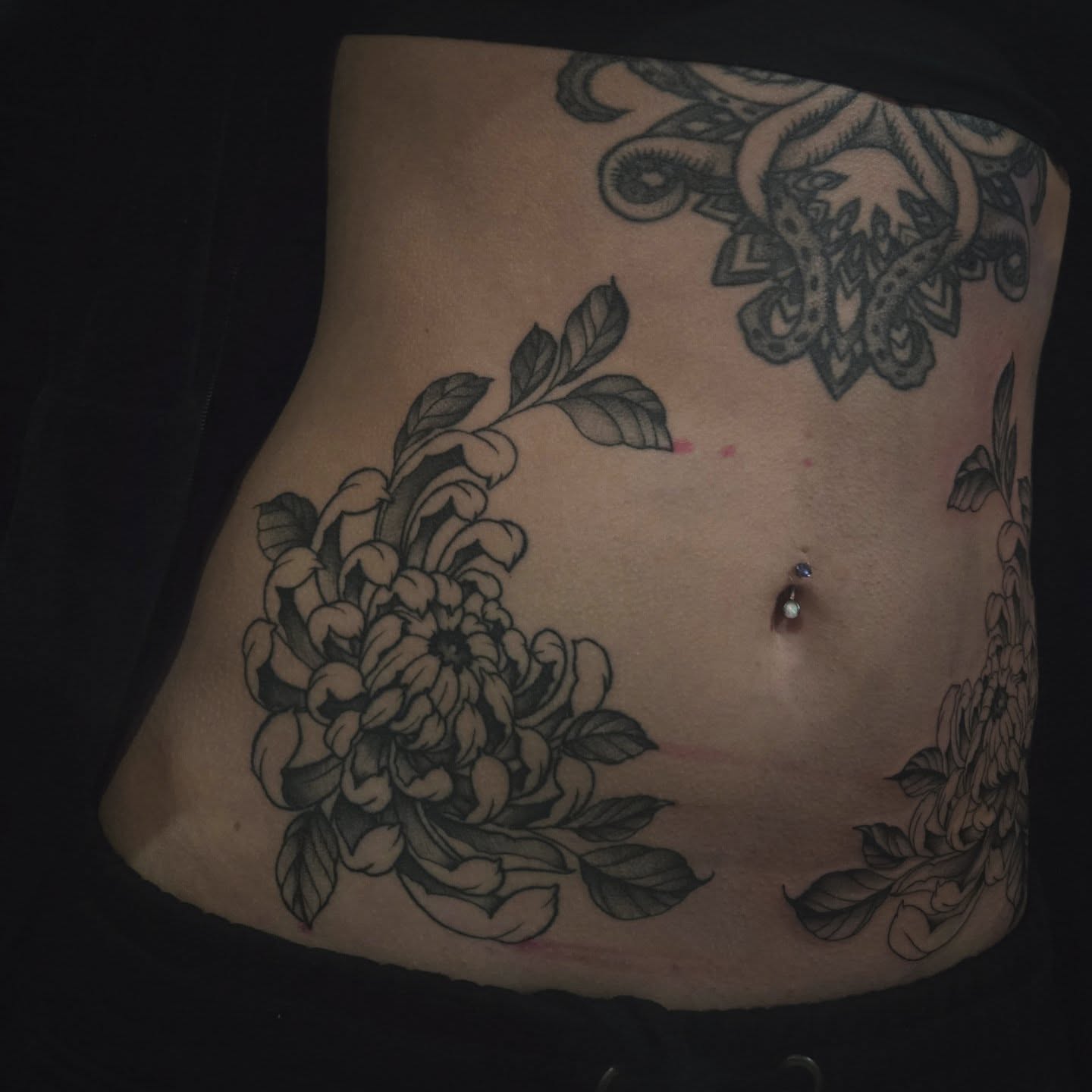 Chrysanthemum black and grey tattoo on the torso by Alexandra Colella ✨️