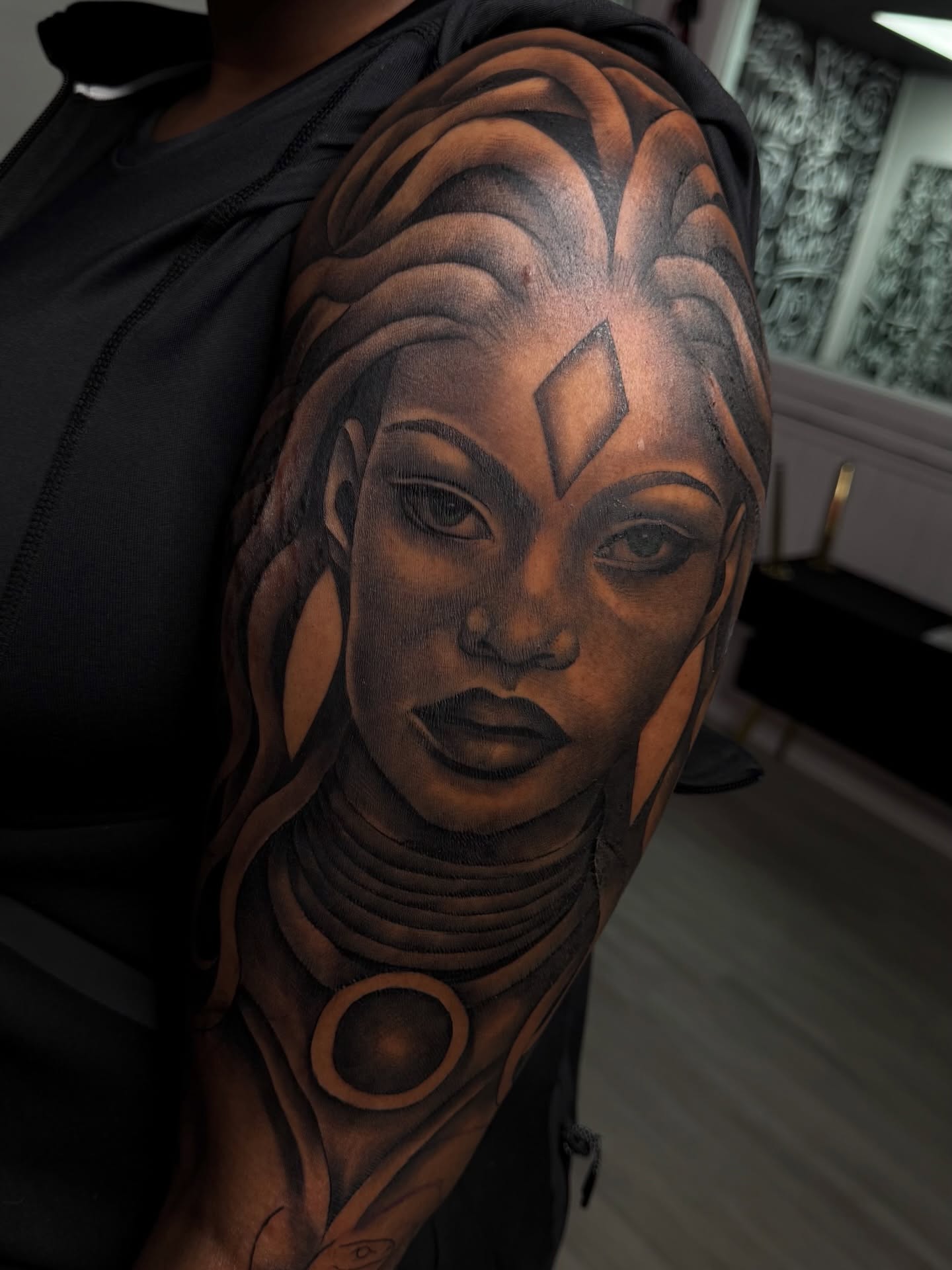 Woman's face realism tattoo on the upper arm by Savannah Tattoo Artist