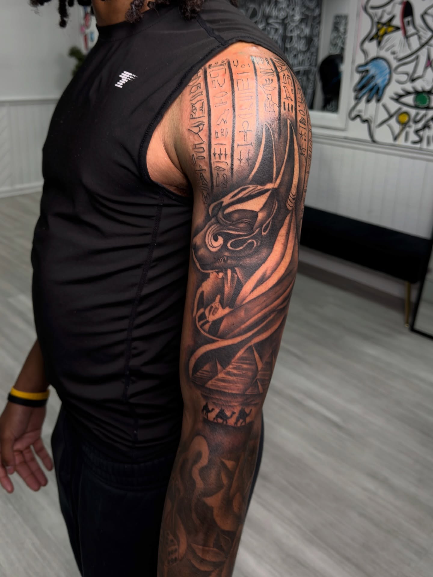 Ancient egyptian deity geometric tattoo on the upper arm by Savannah Tattoo Artist