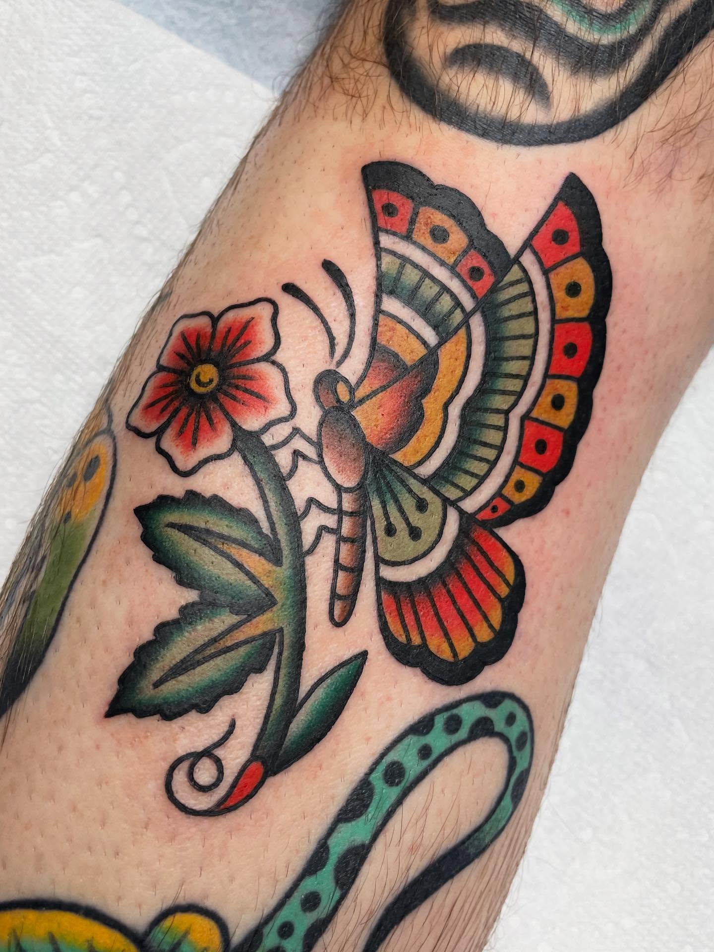 Butterfly and flower American traditional tattoo on the forearm by Kat, Sacramento, California
