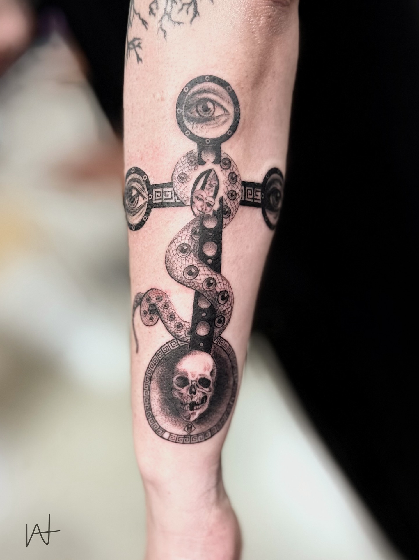 Snake and skull geometric tattoo on the forearm by Kat Parmu