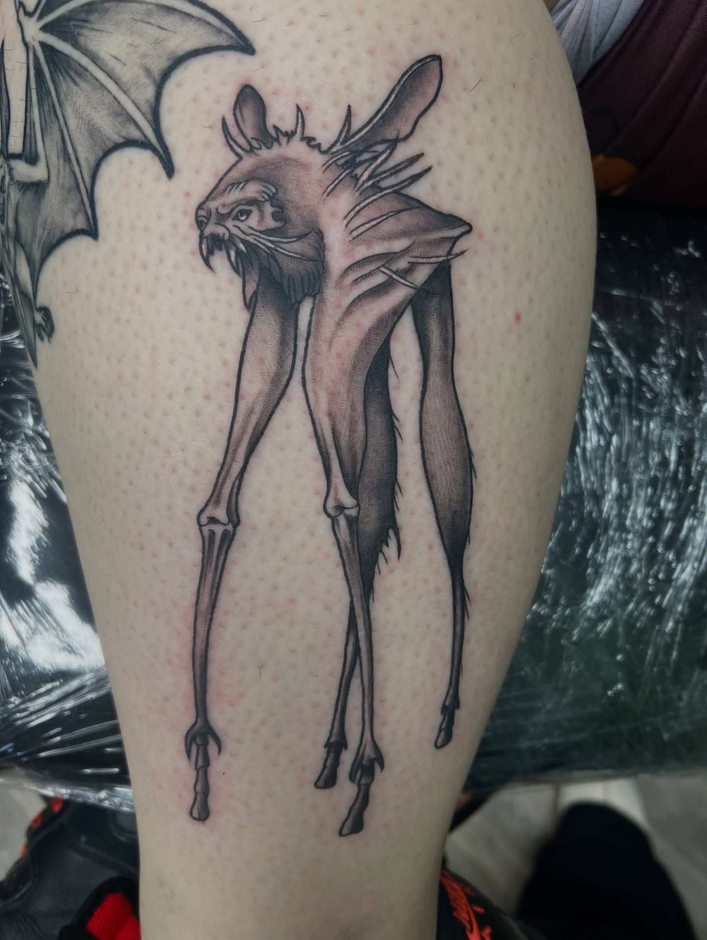 Goat-like creature black and grey tattoo on the thigh by Olivia Suzanne Fada