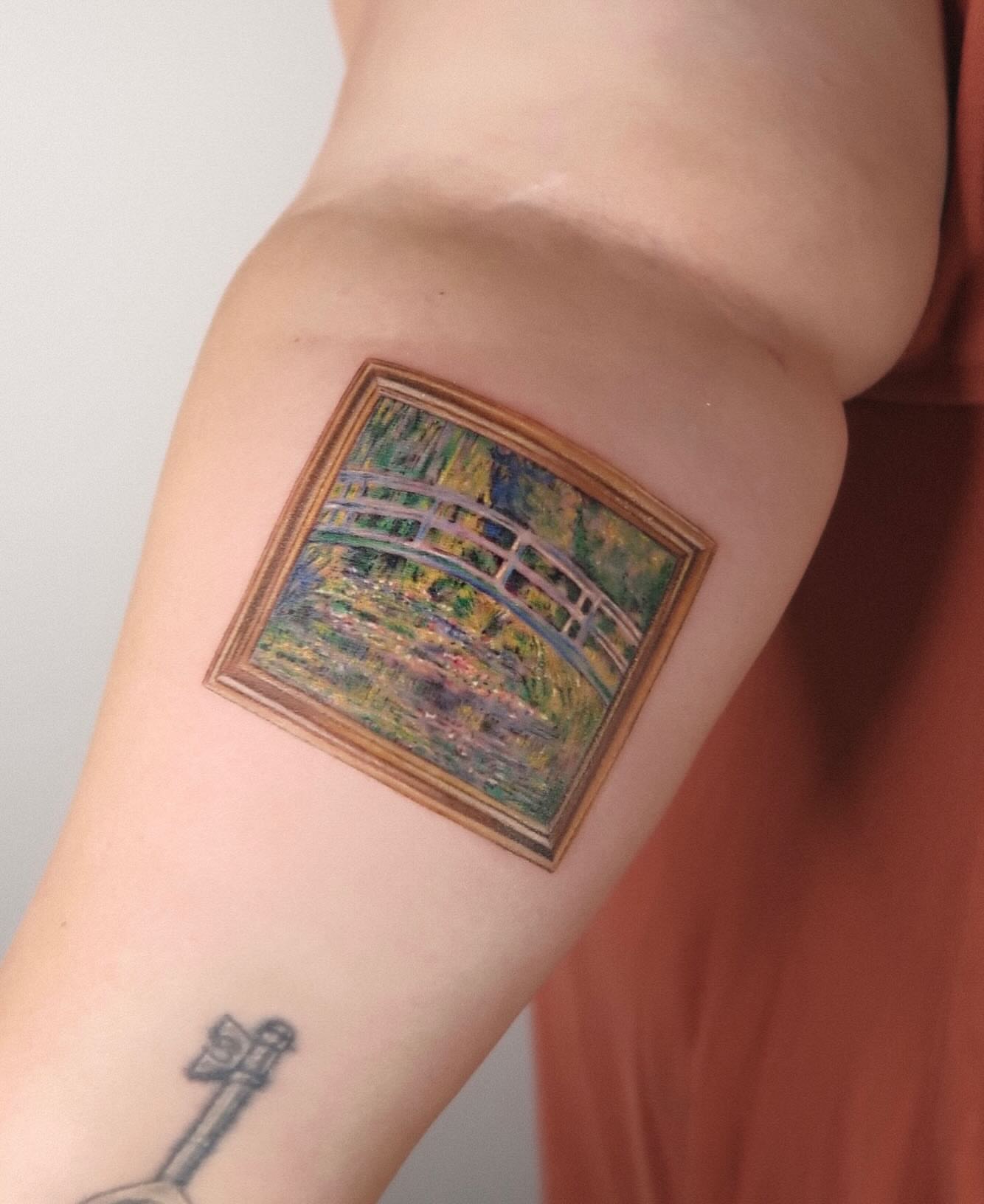 Bridge and garden realism tattoo on the forearm by Alissa Jung