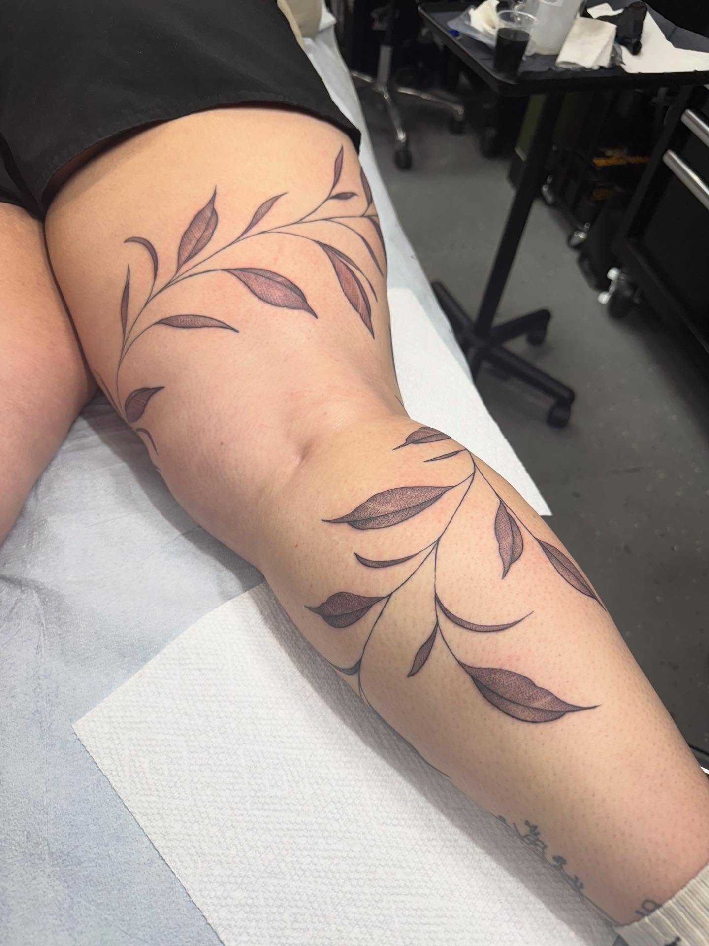 Leaf vine black and grey tattoo on the thigh by Maddie Jo DeYoung