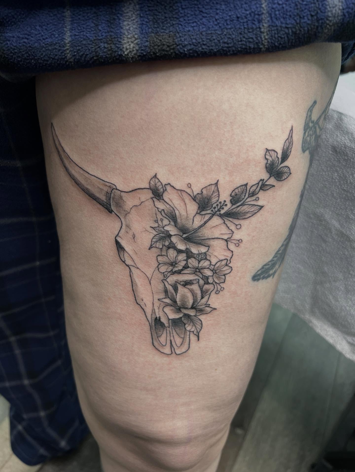 Bull skull with flowers black and grey tattoo on the thigh by Monii Arreola