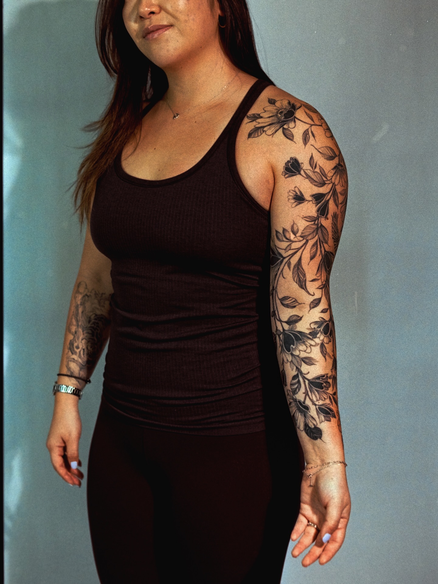 Floral vine black and grey tattoo on the upper arm by Brad Simmons