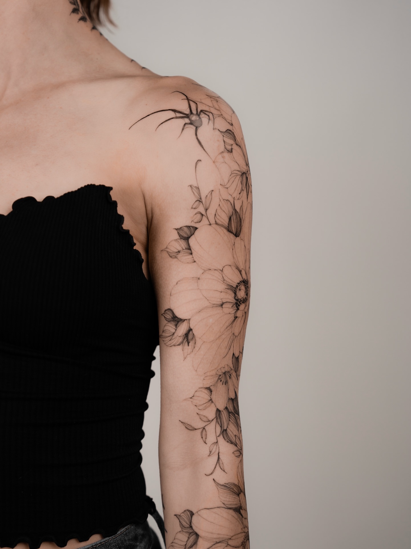 Flower and spider realism tattoo on the upper arm by Marek