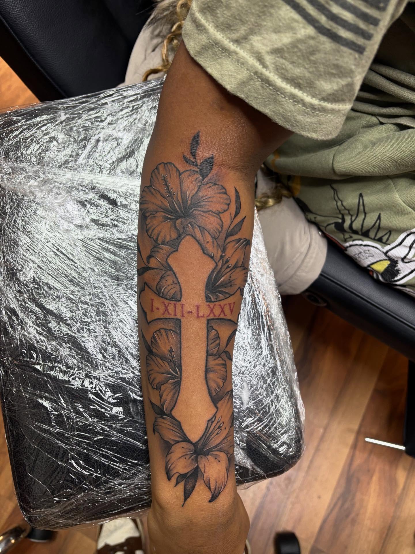 Cross with floral elements black and grey tattoo on the forearm by 𓂀 𝕊ℍ𝔼𝕃𝕃𝕐 𓂀