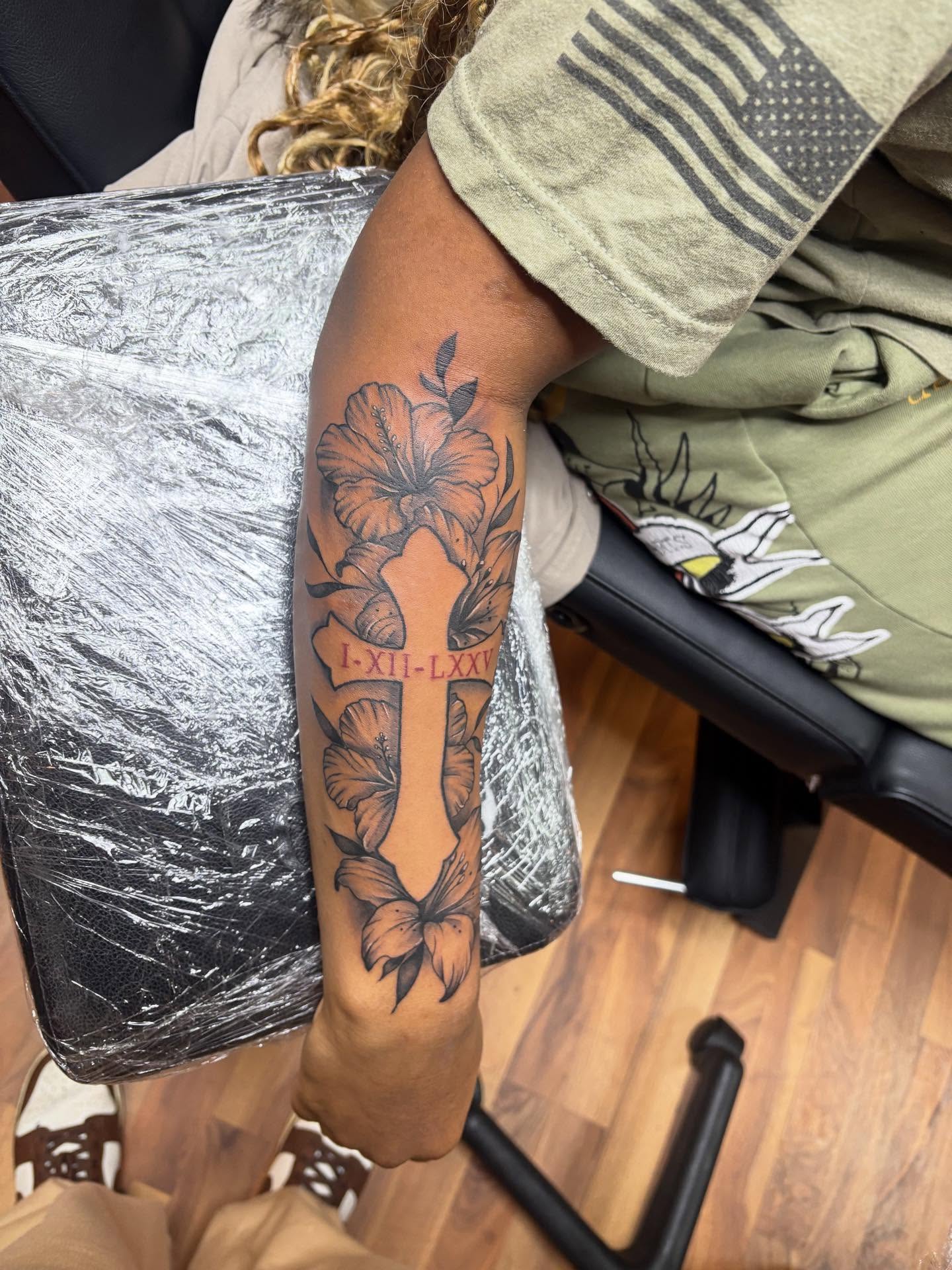 Cross with floral elements black and grey tattoo on the forearm by 𓂀 𝕊ℍ𝔼𝕃𝕃𝕐 𓂀