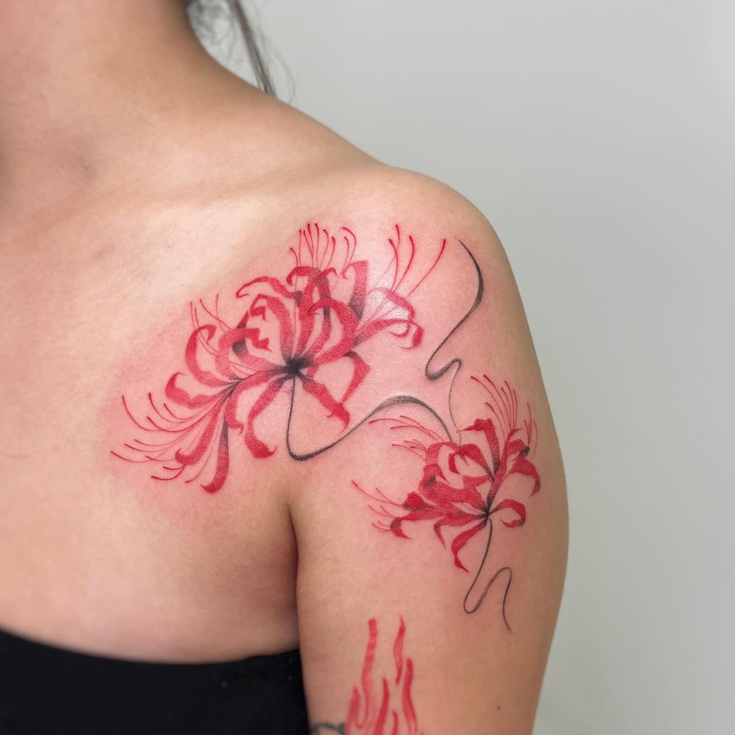 Red spider lilies watercolor tattoo on the shoulder by David