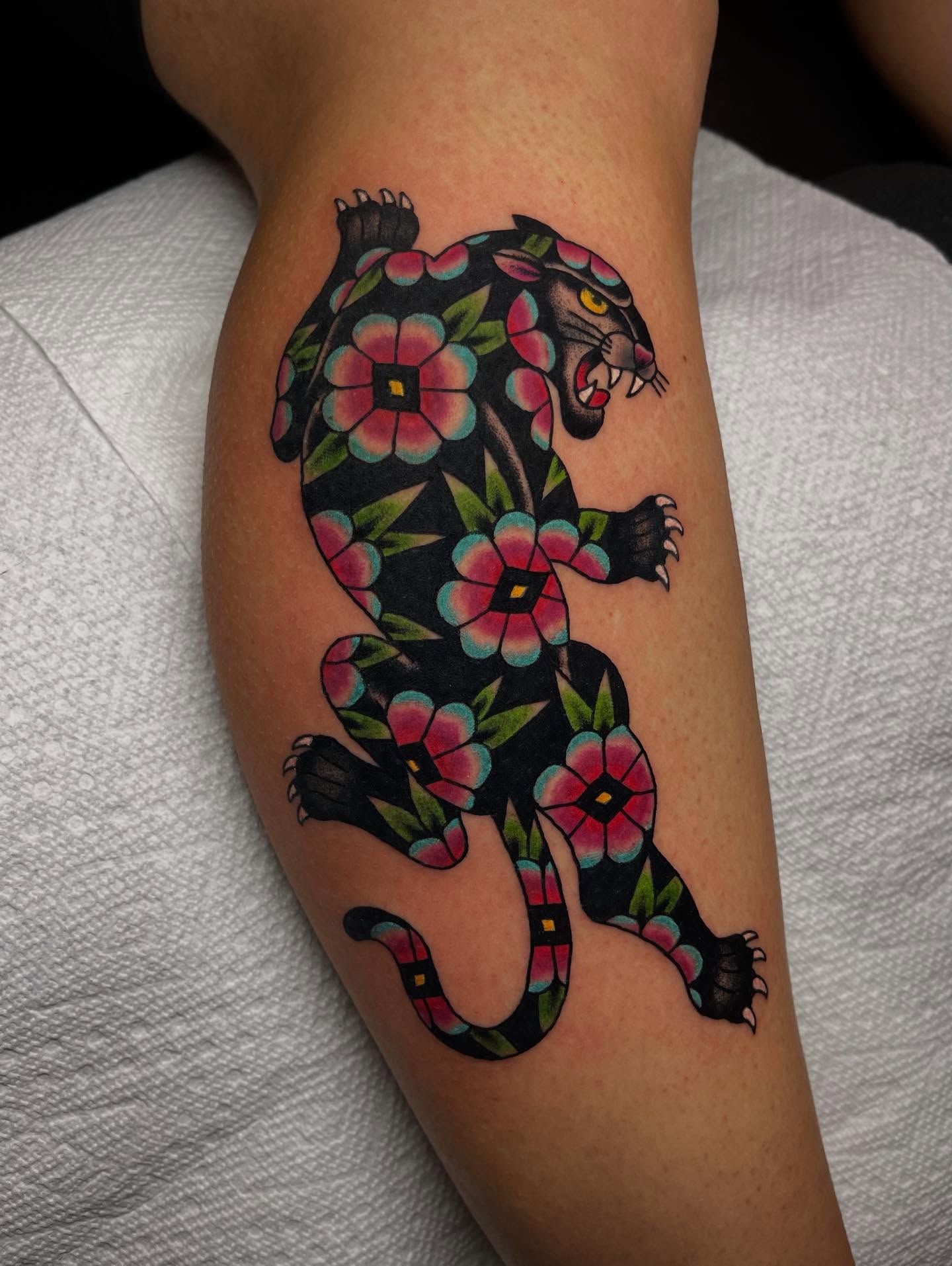 Panther with floral pattern American traditional tattoo on the forearm by Marqui Watling