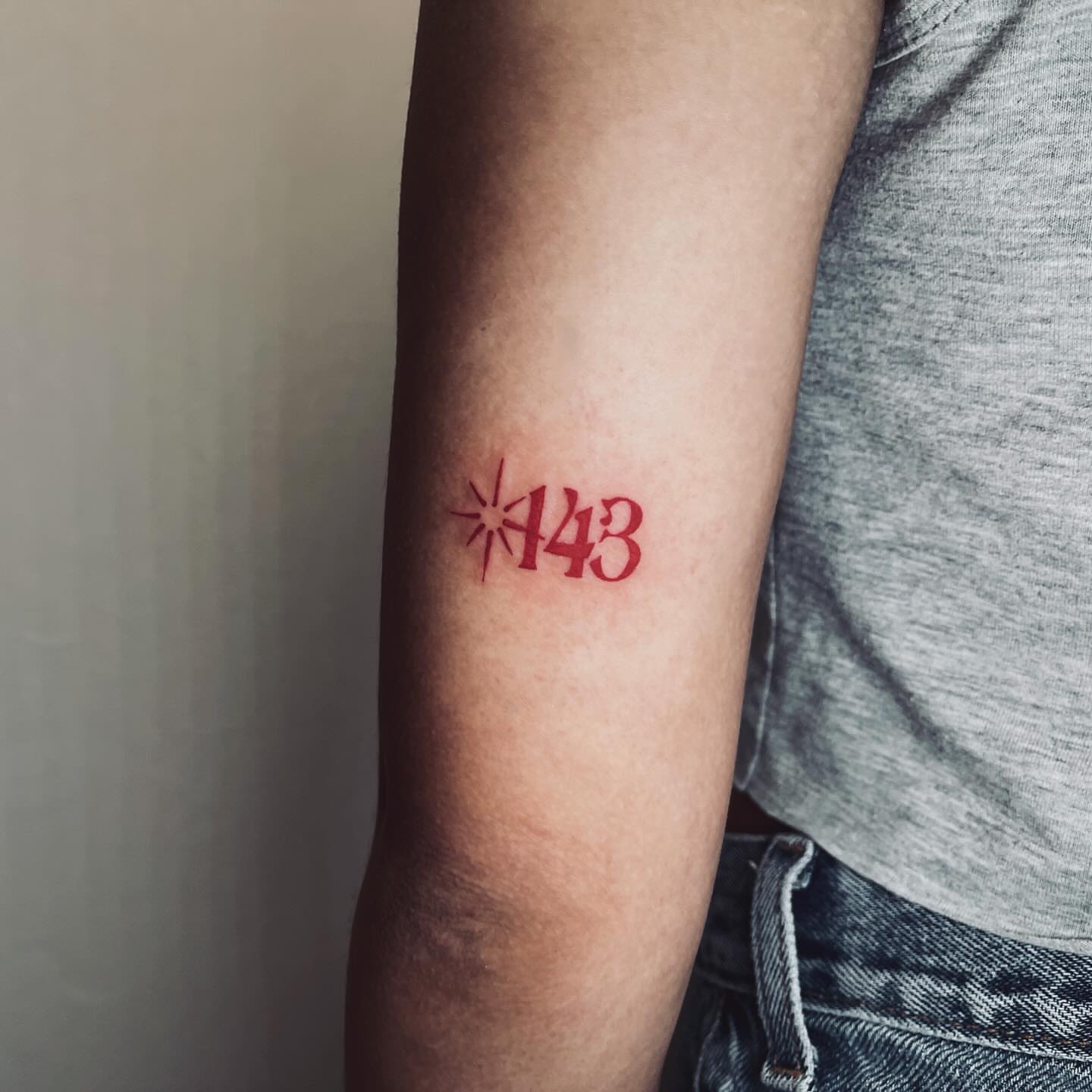 Number 143 lettering script tattoo on the forearm by vivian