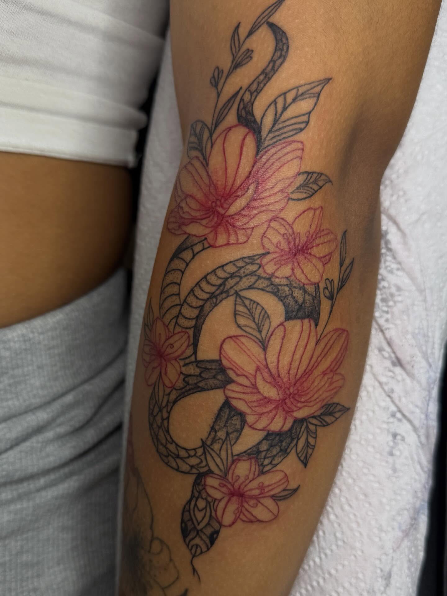 Snake and flowers neo-traditional tattoo on the forearm by Destini