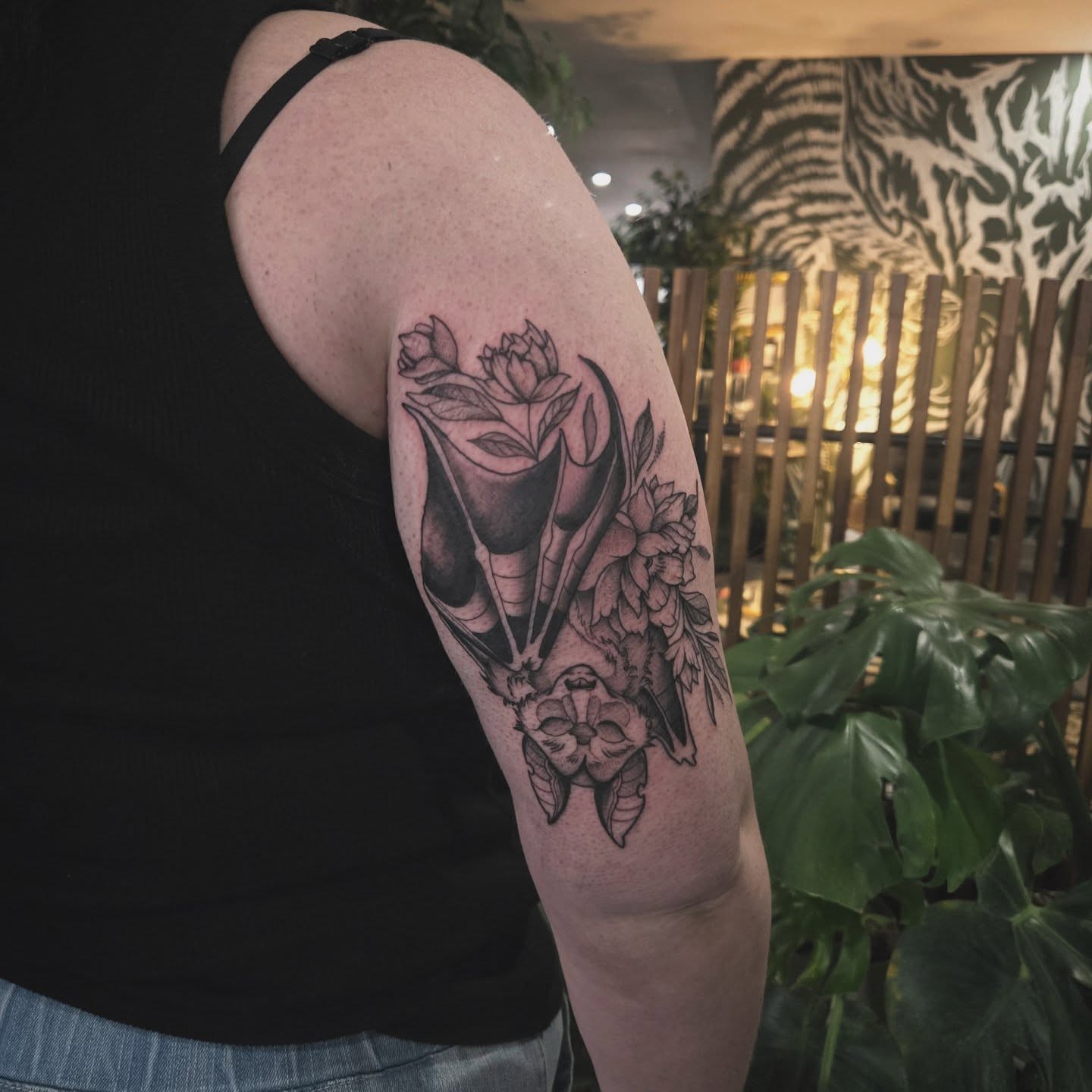 Floral arrangement black and grey tattoo on the upper arm by Alexandra Colella ✨️