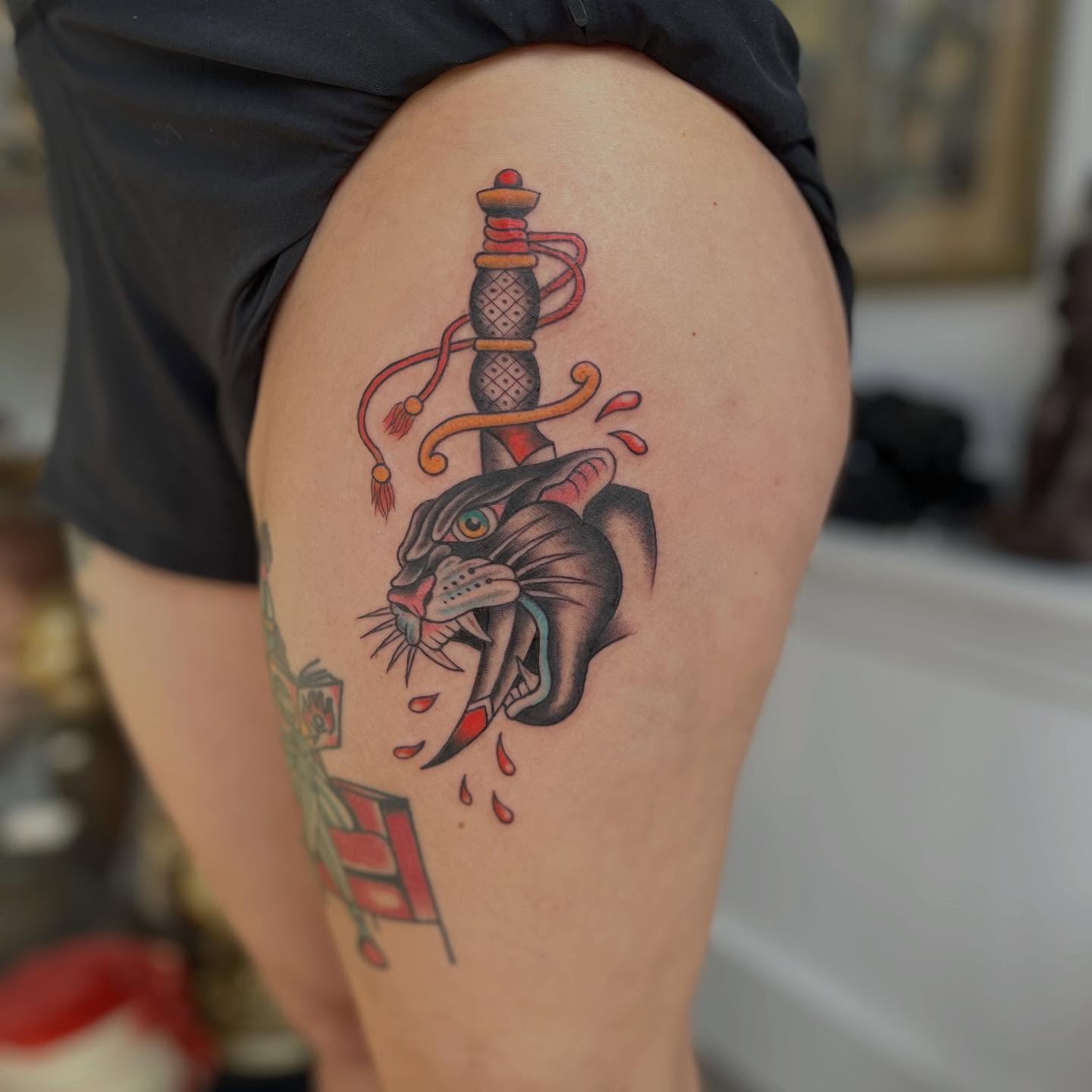 Panther and dagger American traditional tattoo on the thigh by Maddy Anthony