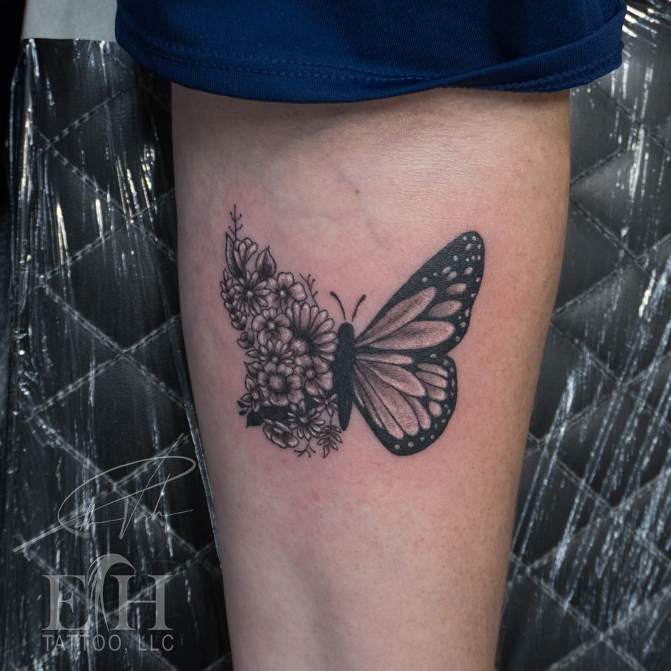 Butterfly and flowers fine line tattoo on the thigh by Donald Voelker