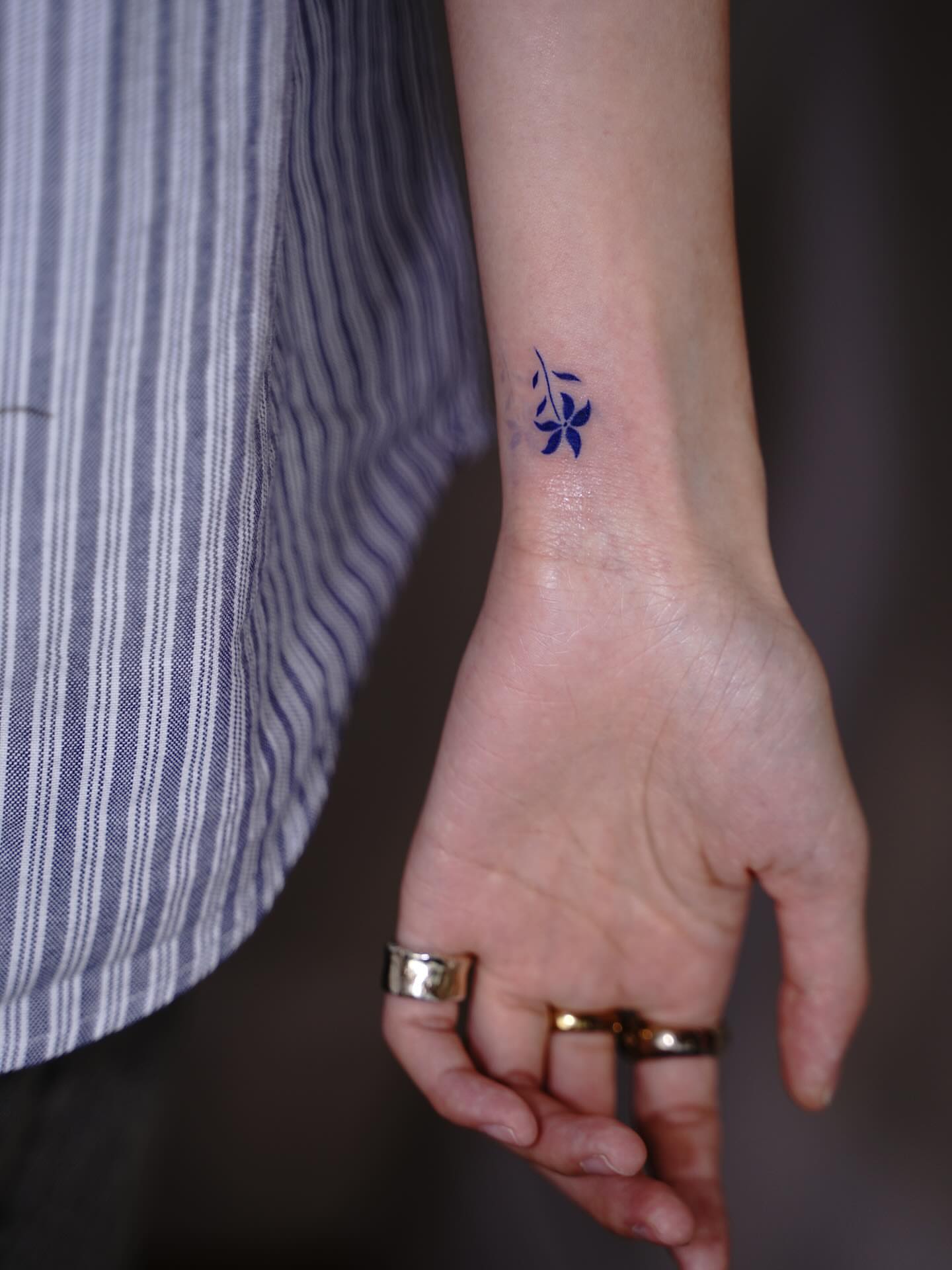 Flower and musical notes fine line tattoo on the forearm by Tomato