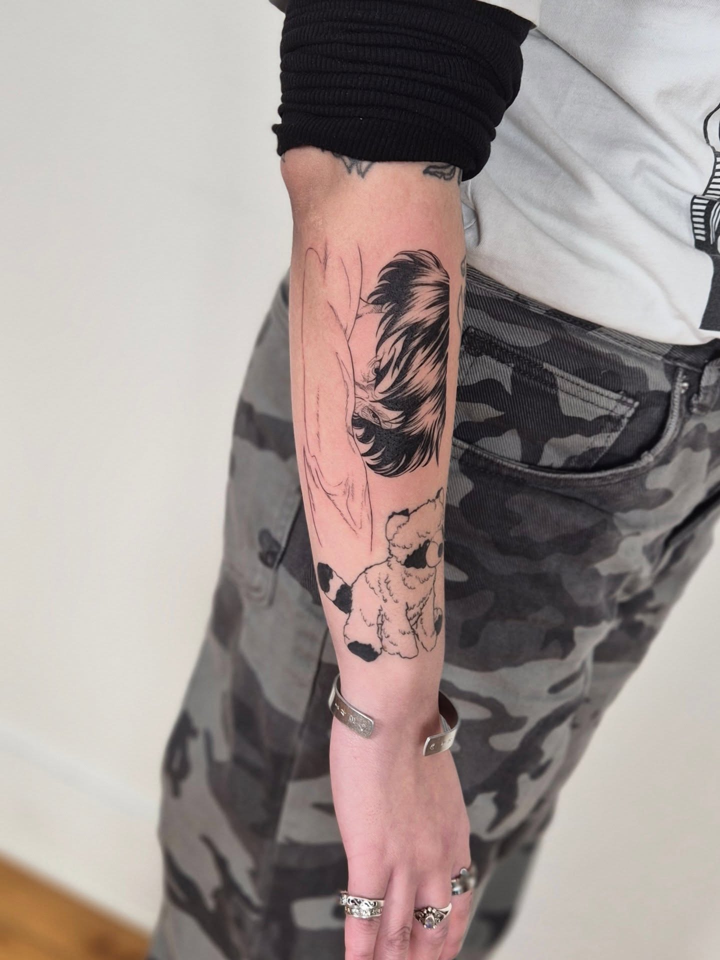 Woman with dog black and grey tattoo on the forearm by Sophorn Long (soapy)