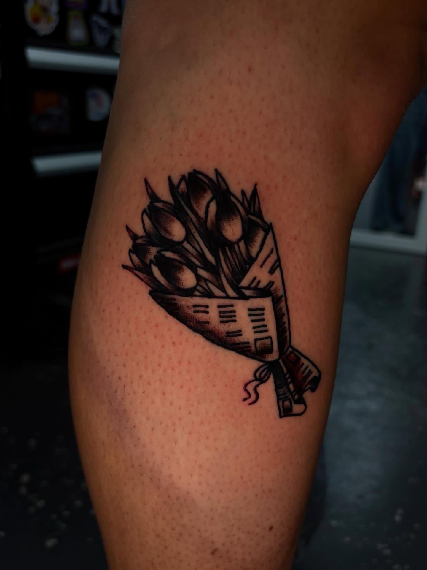 Basket of flowers black and grey tattoo on the thigh by Jenna Clayton