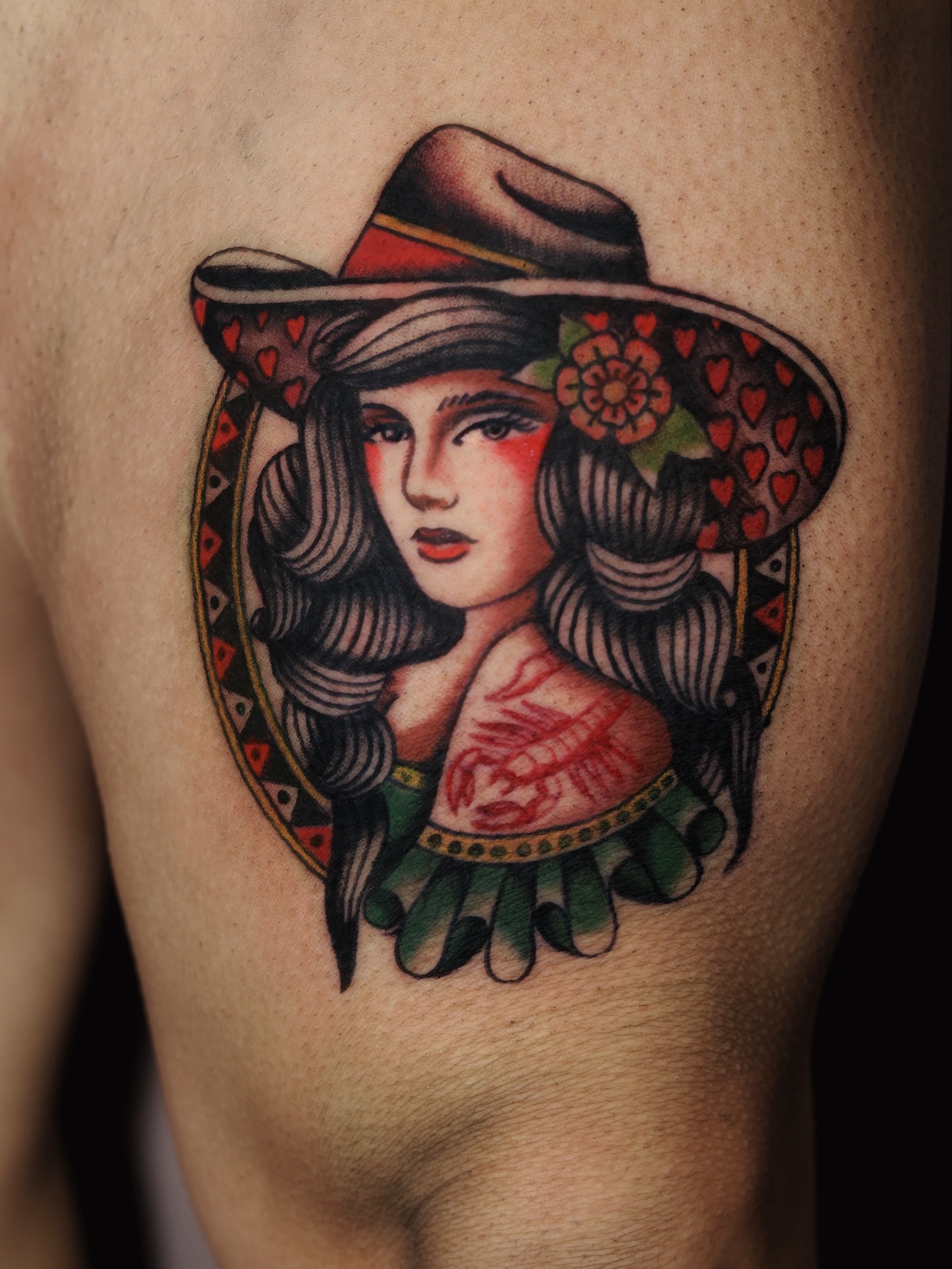 Woman wearing hat American traditional tattoo on the thigh by Dylan Mott