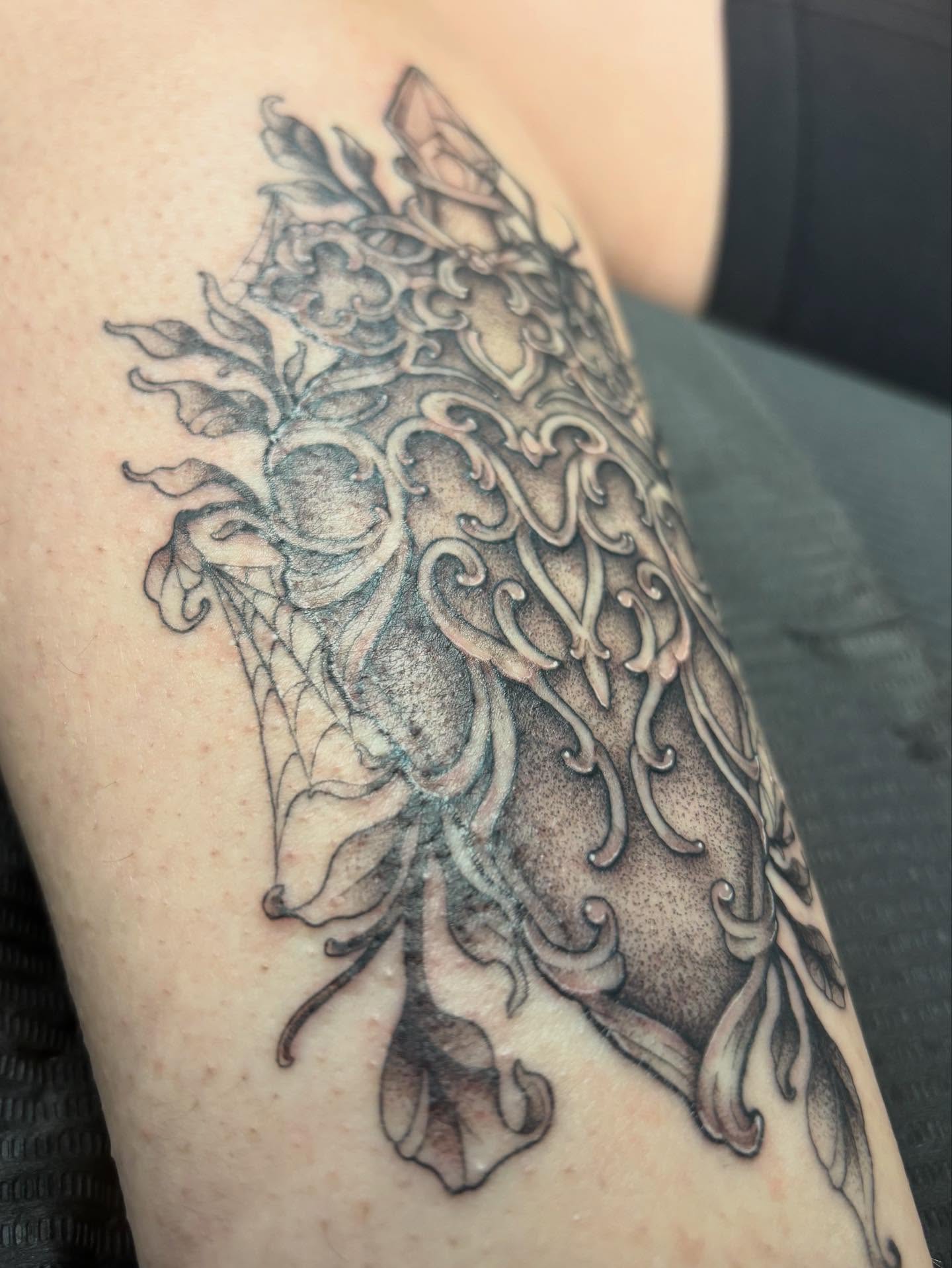 Owl black and grey tattoo on the upper arm by Rachel Foster