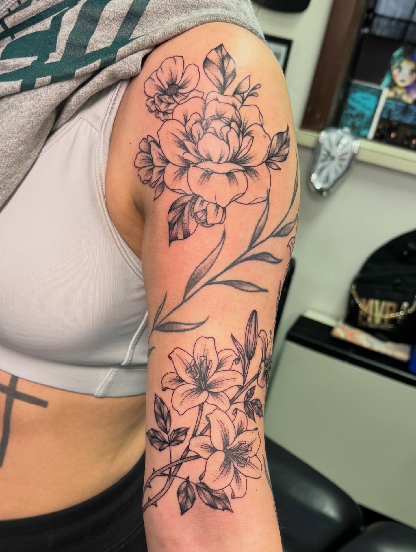 Floral bouquet black and grey tattoo on the upper arm by haylie