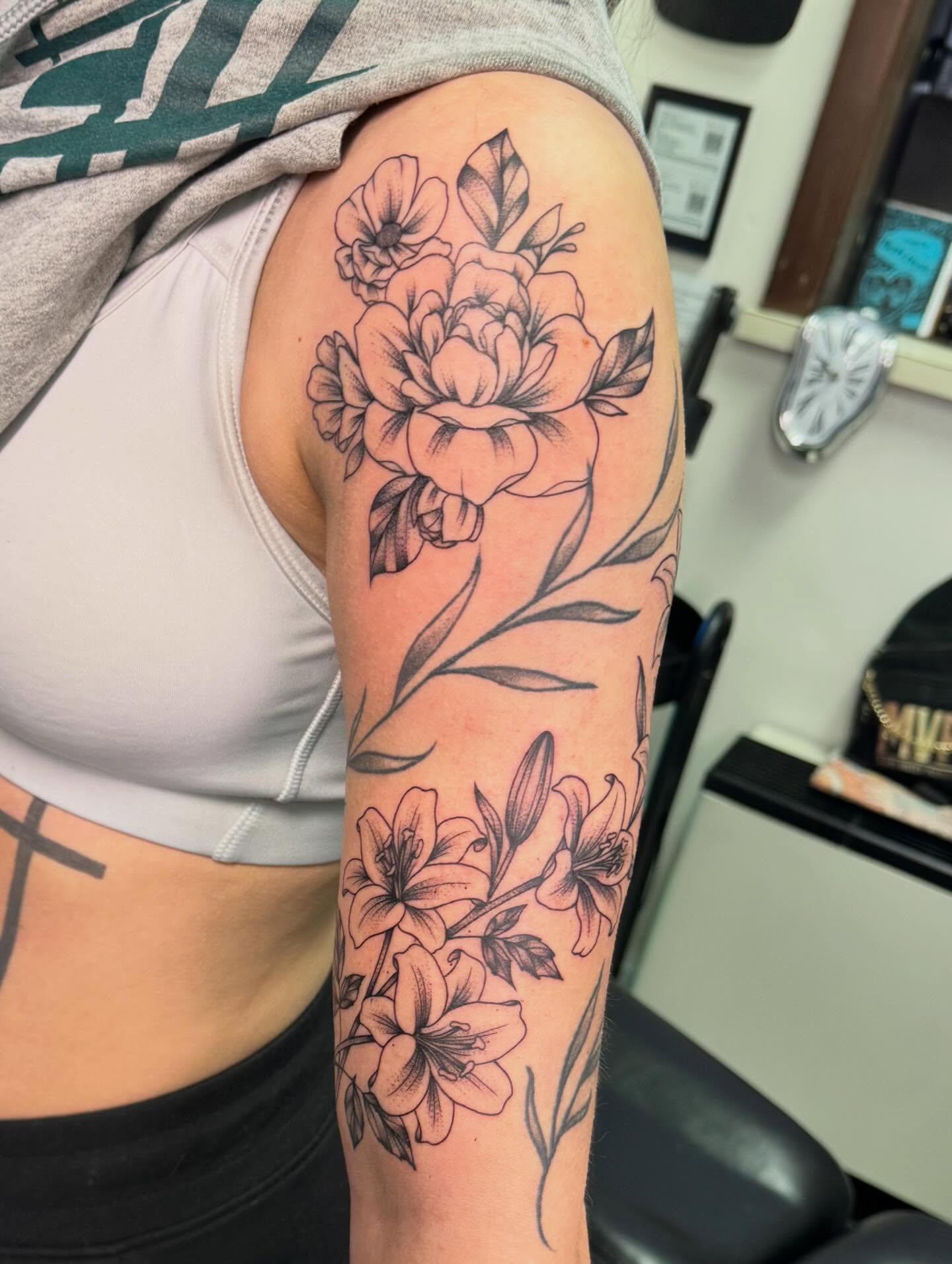 Floral bouquet black and grey tattoo on the upper arm by haylie