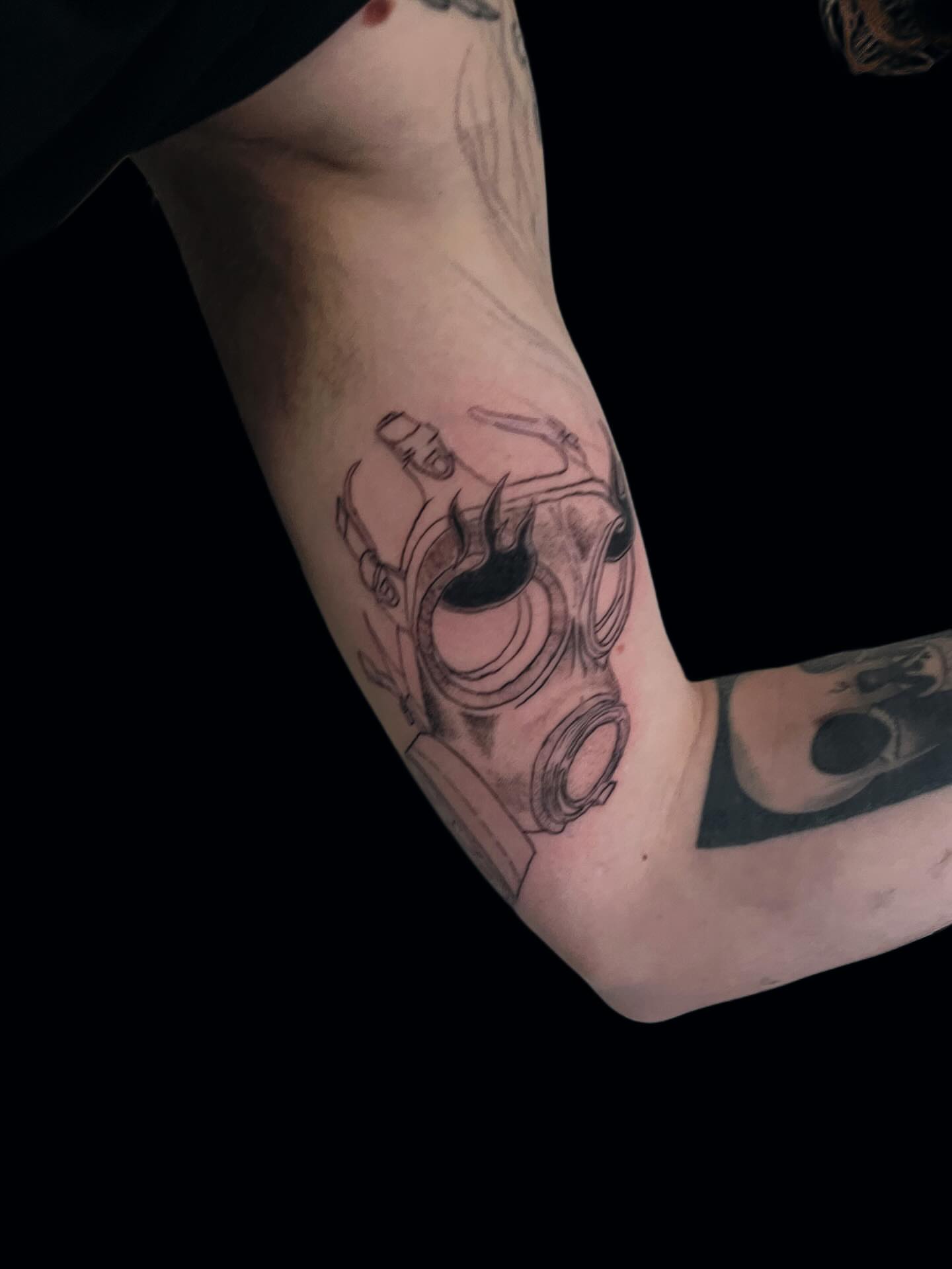 Gas mask black and grey tattoo on the forearm by Dev