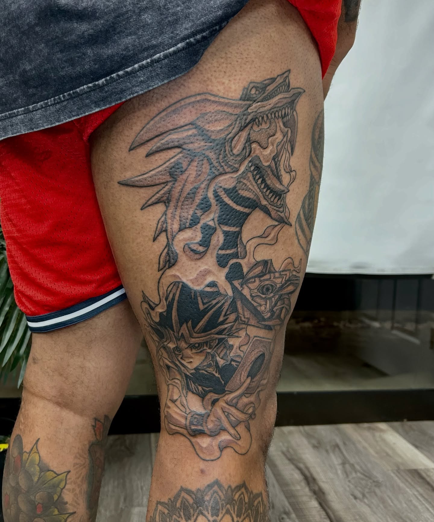 Dragon and yu-gi-oh character realism tattoo on the thigh by Taylor Heidtbrink