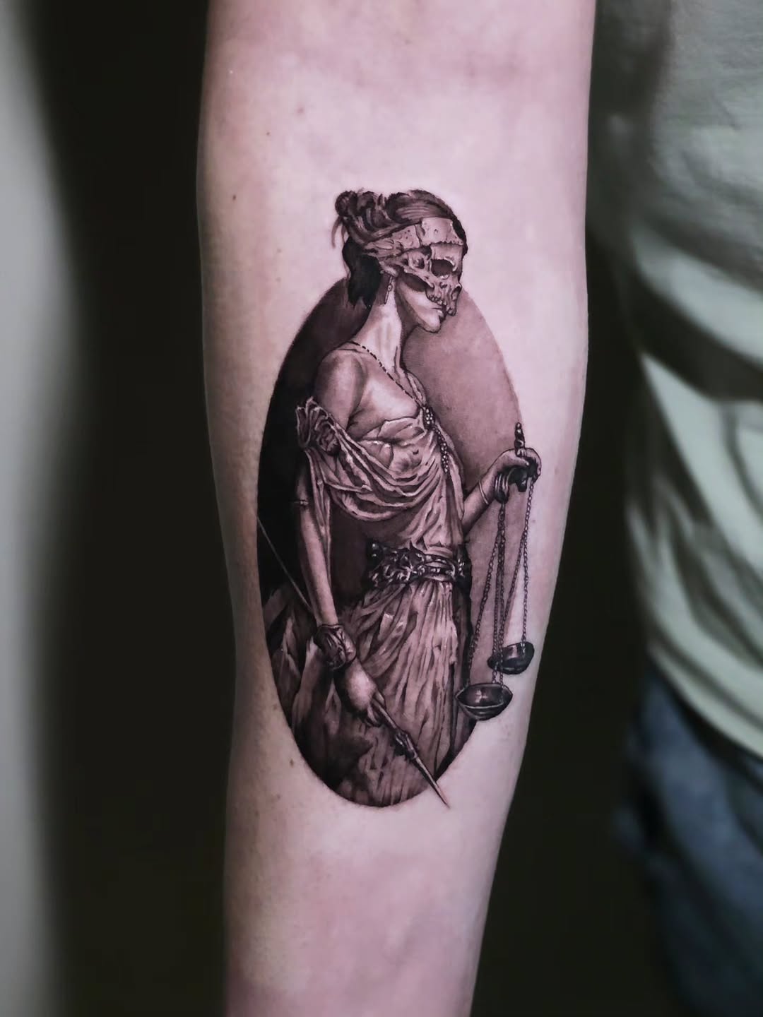 Lady Justice with skull mask realism tattoo on the forearm by Jake Barney