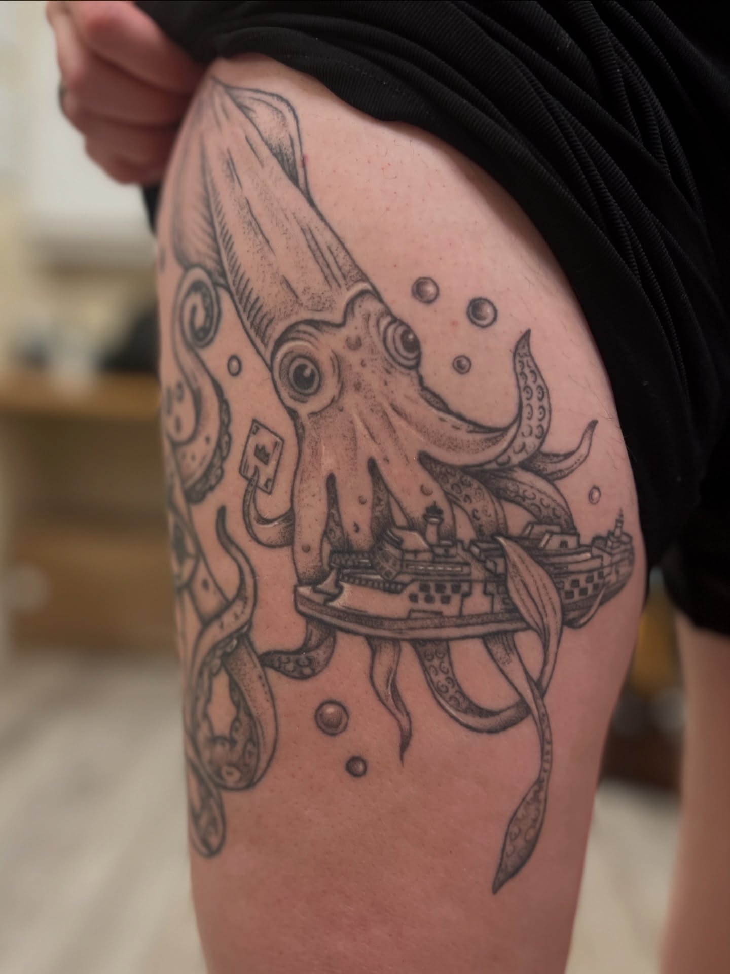 Octopus and ship black and grey tattoo on the thigh by Kelsi Hooper, Seattle, Washington