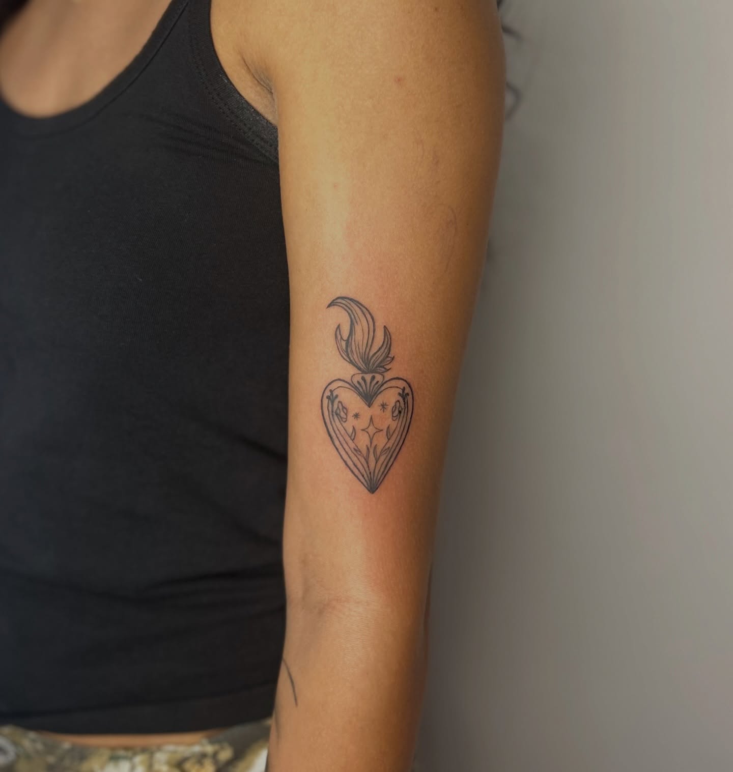 Heart with flame black and grey tattoo on the forearm by Sarah