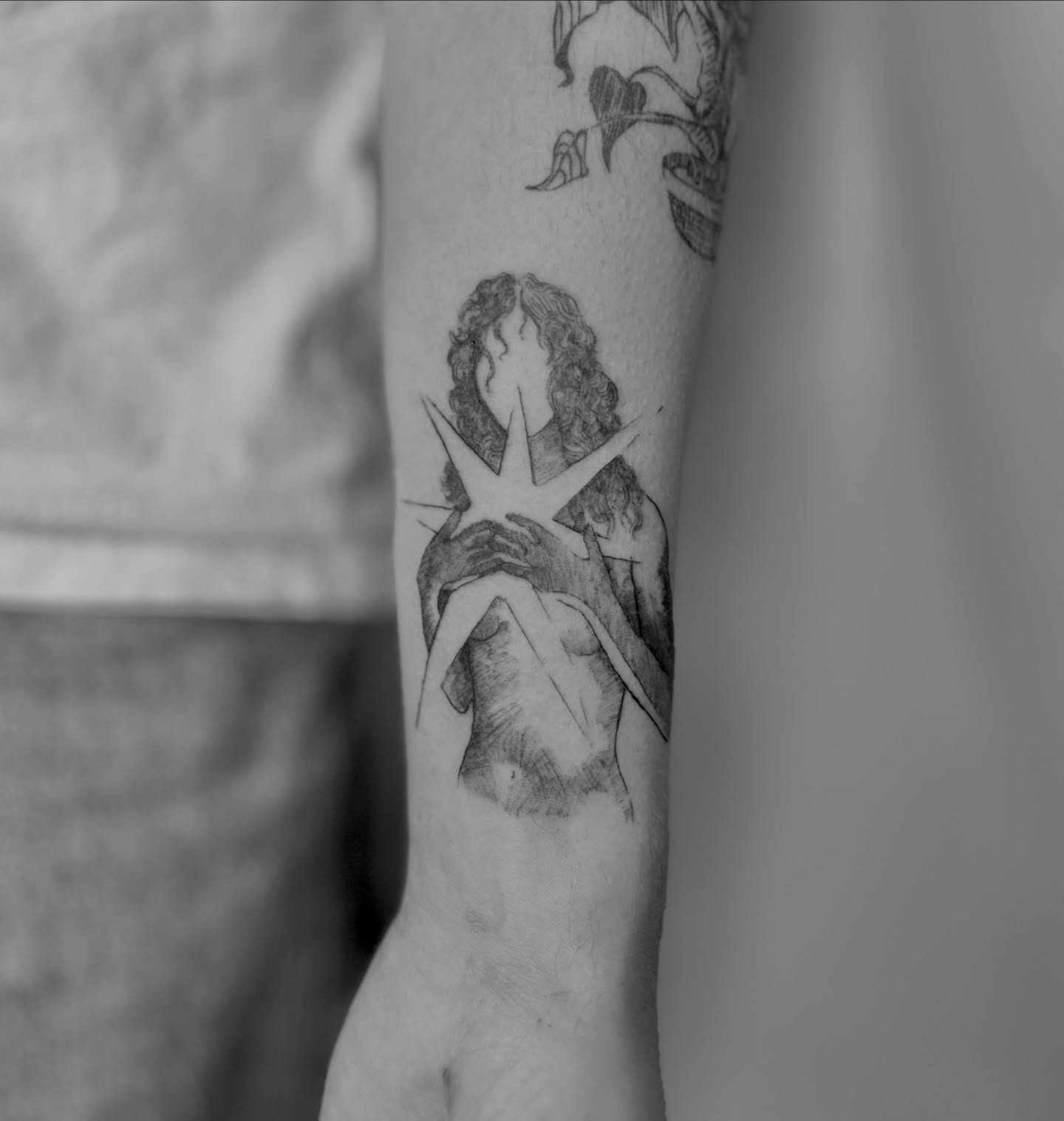 Kissing couple black and grey tattoo on the forearm by Sarah