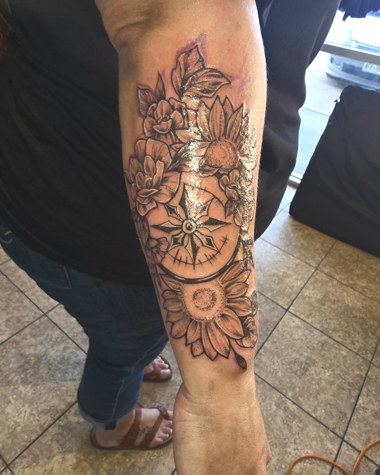 Sunflowers and compass black and grey tattoo on the forearm by Jessica DarkRabbit