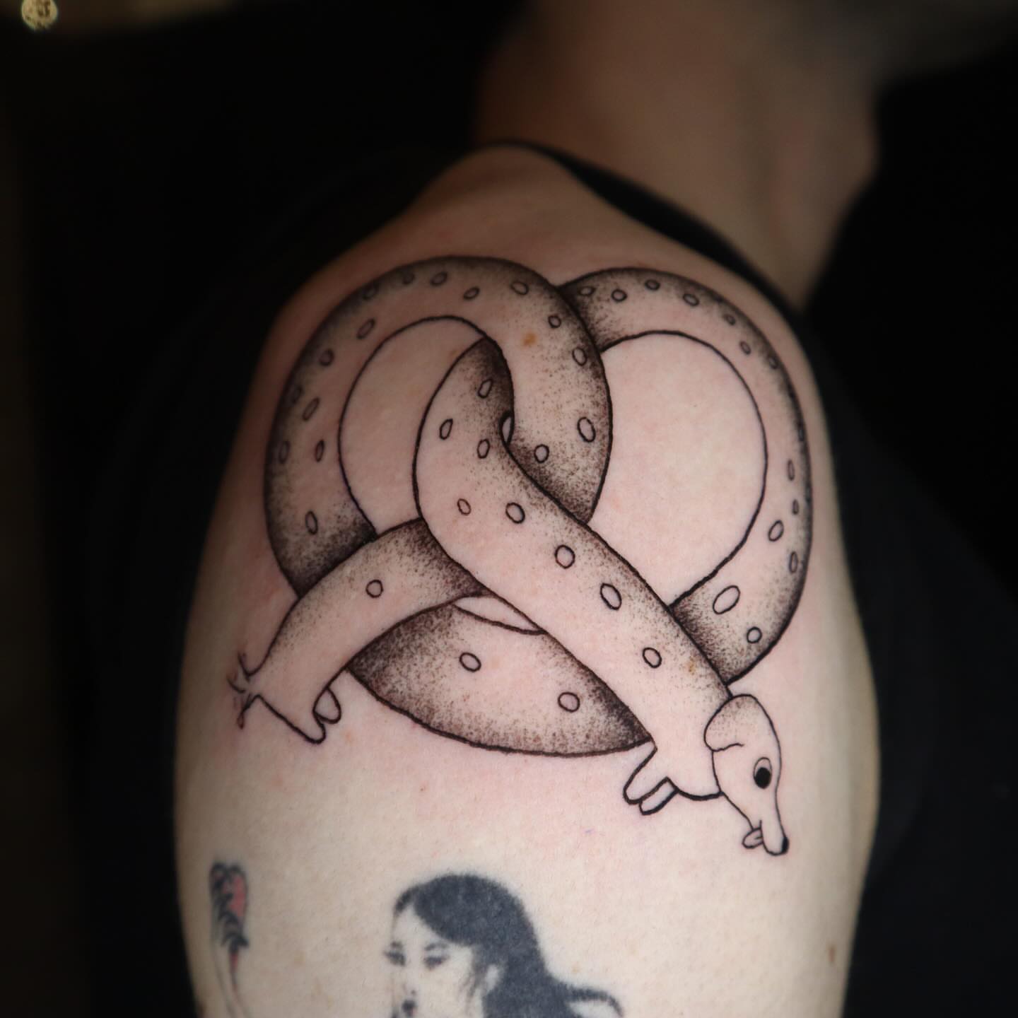 Pretzel snake dotwork tattoo on the shoulder by dani