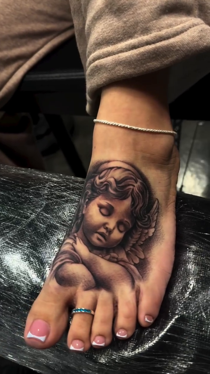 Cherub face realism tattoo by Carlos Lujan