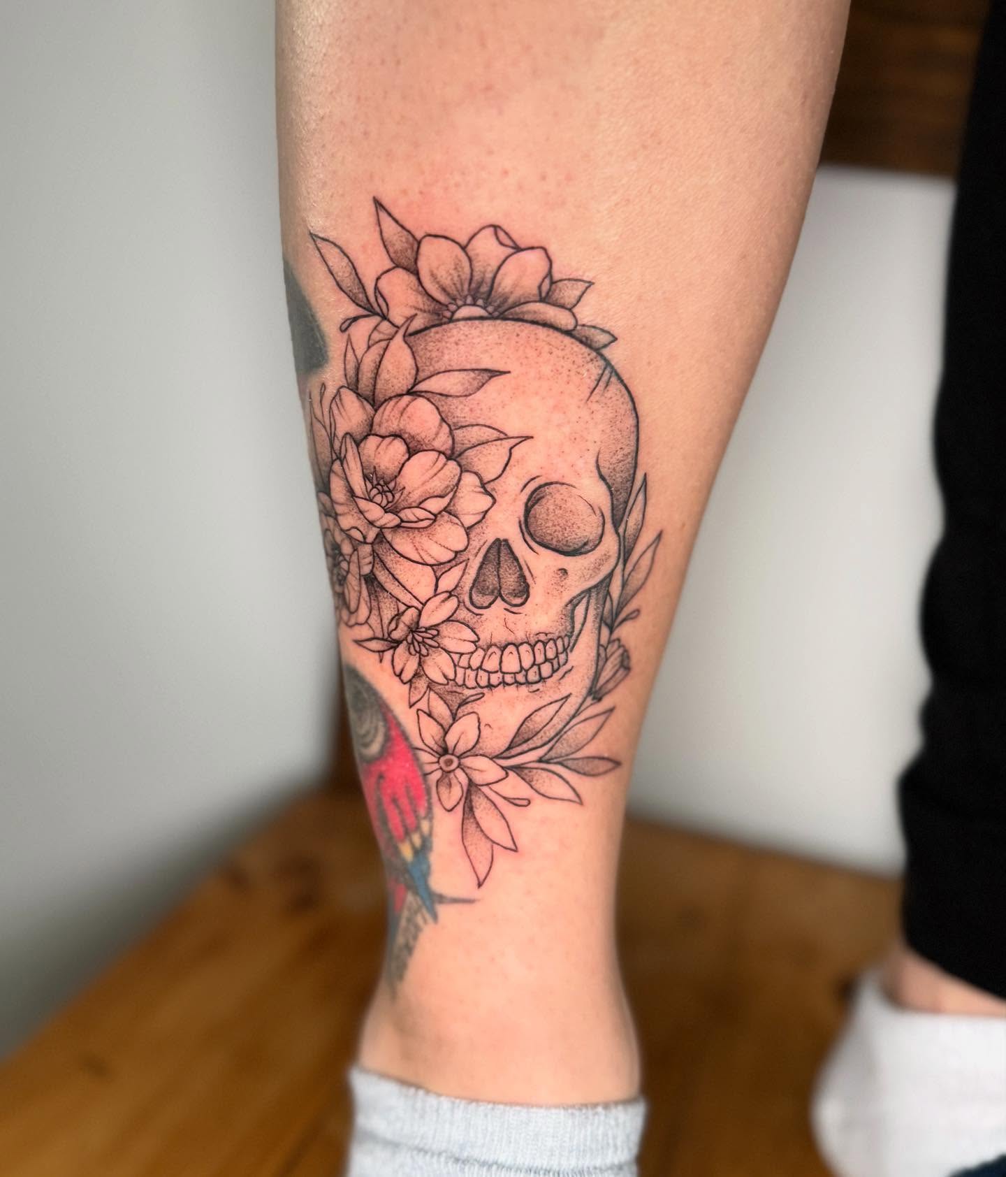 Skull with flowers black and grey tattoo on the forearm by Felicity