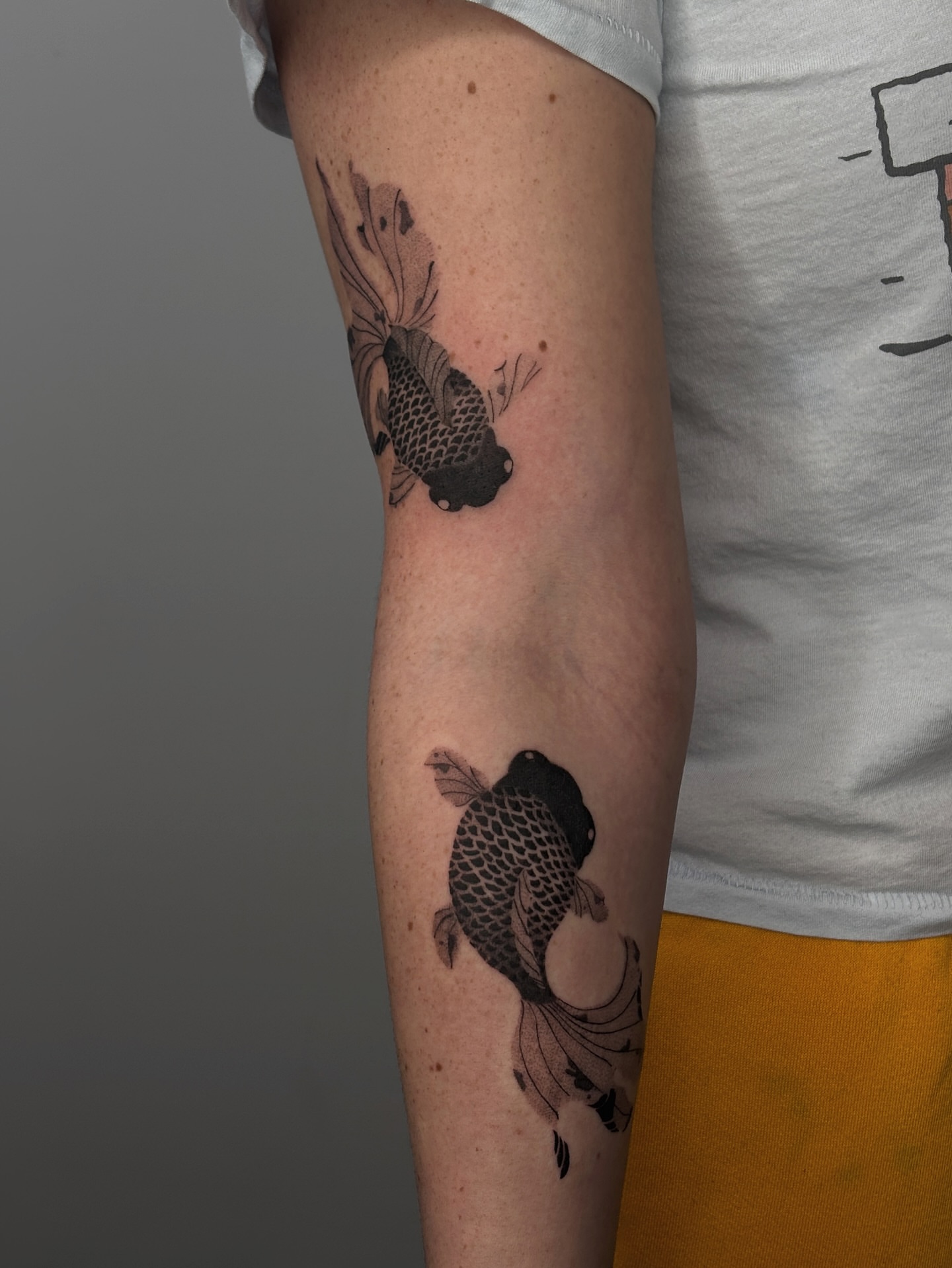 Koi fish black and grey tattoo on the forearm by sago, Berkeley, California