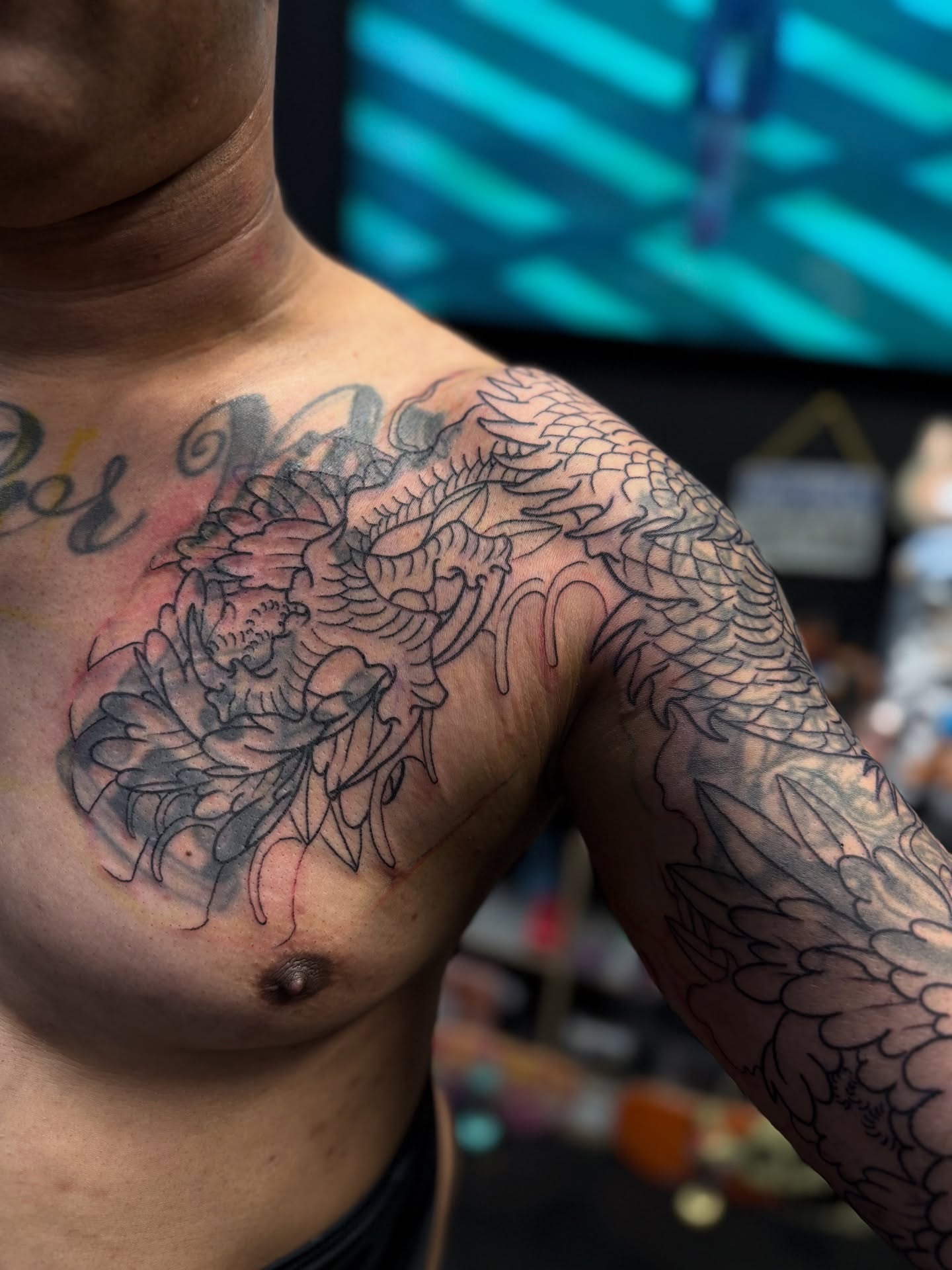 Peony and dragon black and grey tattoo on the chest by Zack Yang, Houston, Texas