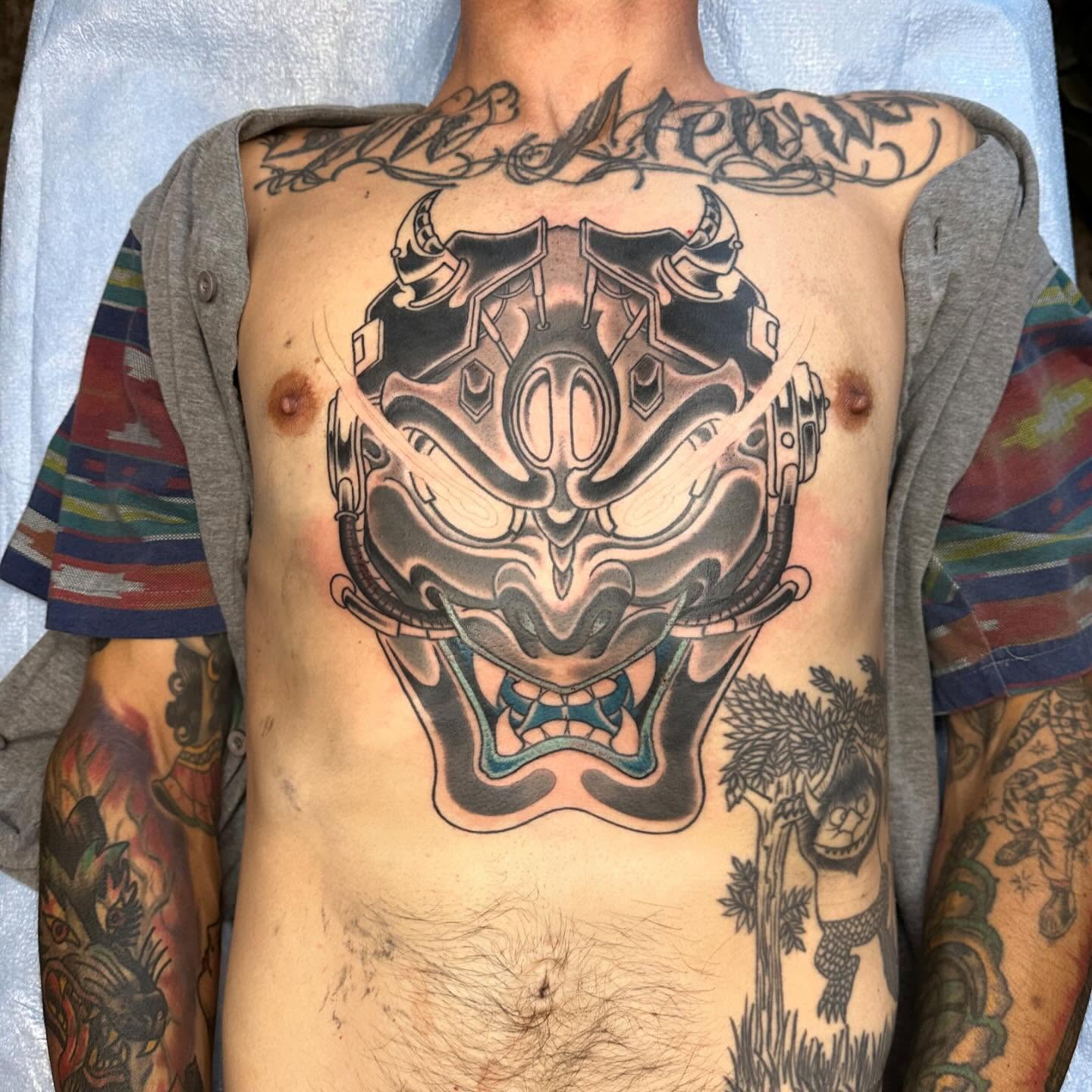 Mask black and grey tattoo on the chest by Tony Medellin 7X9X