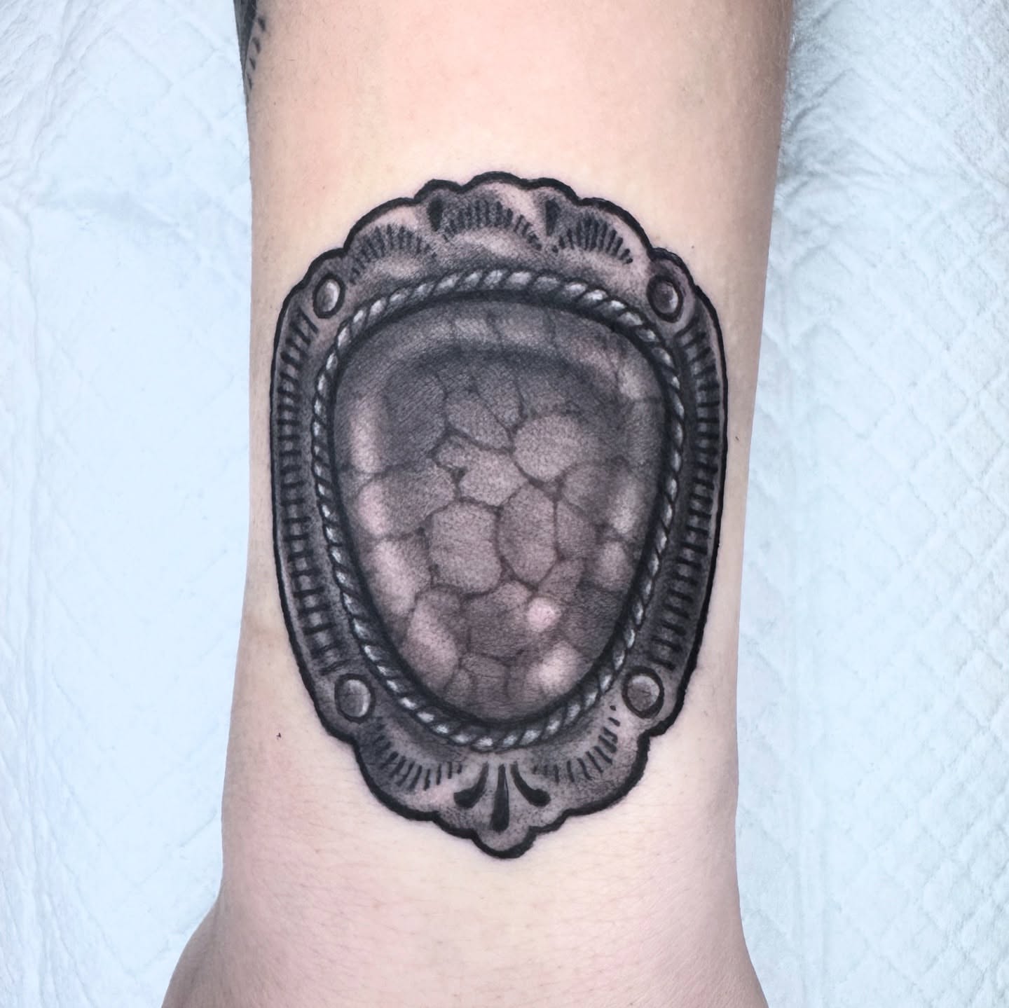 Shell black and grey tattoo on the forearm by Lisa Del Toro
