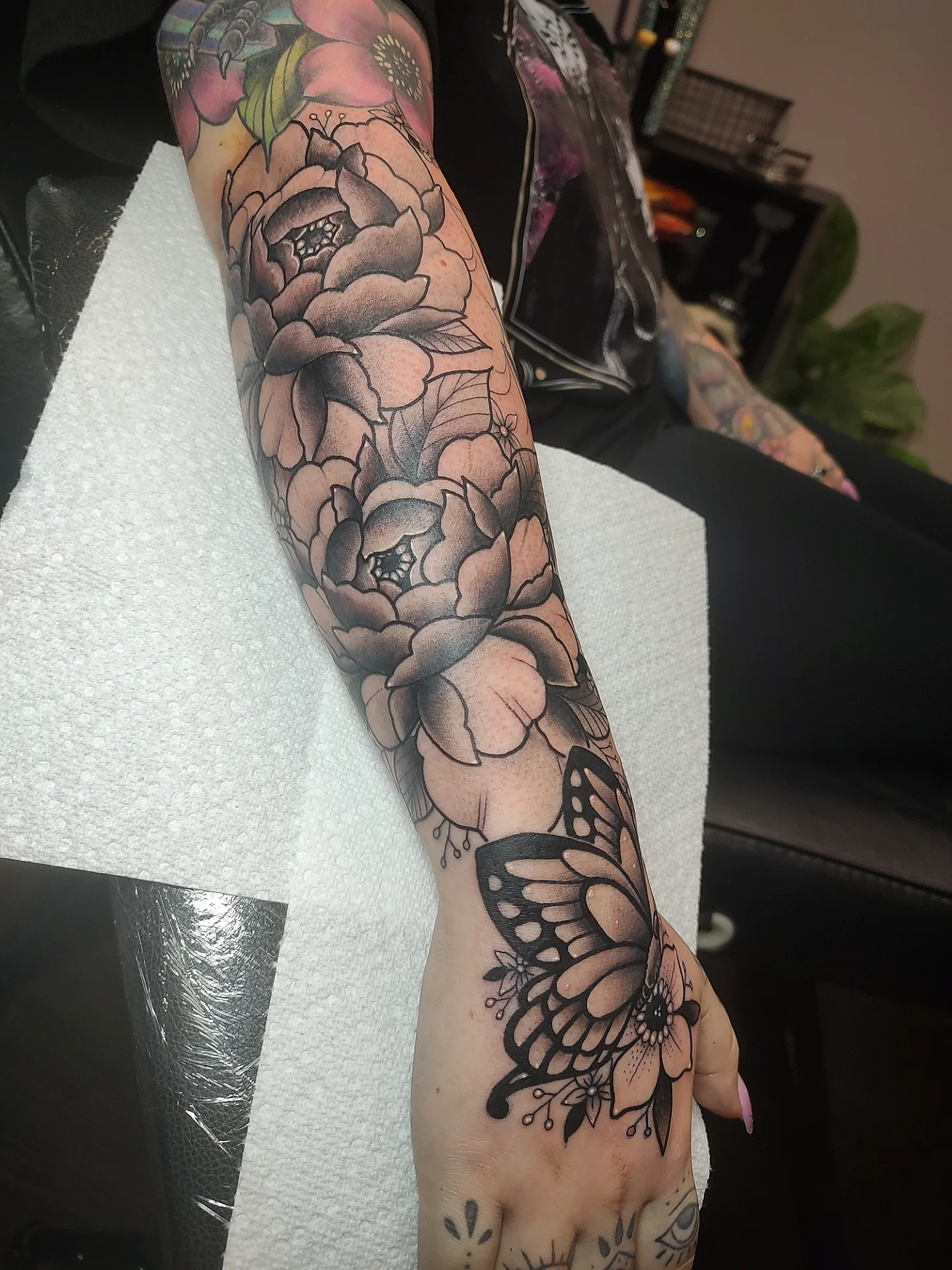 Peony and butterfly black and grey tattoo on the forearm by Jennifer Fowler